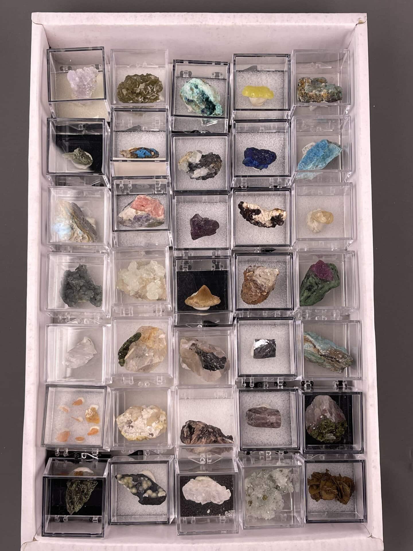 Boxed mineral specimen collection with labeled crystals for display and study