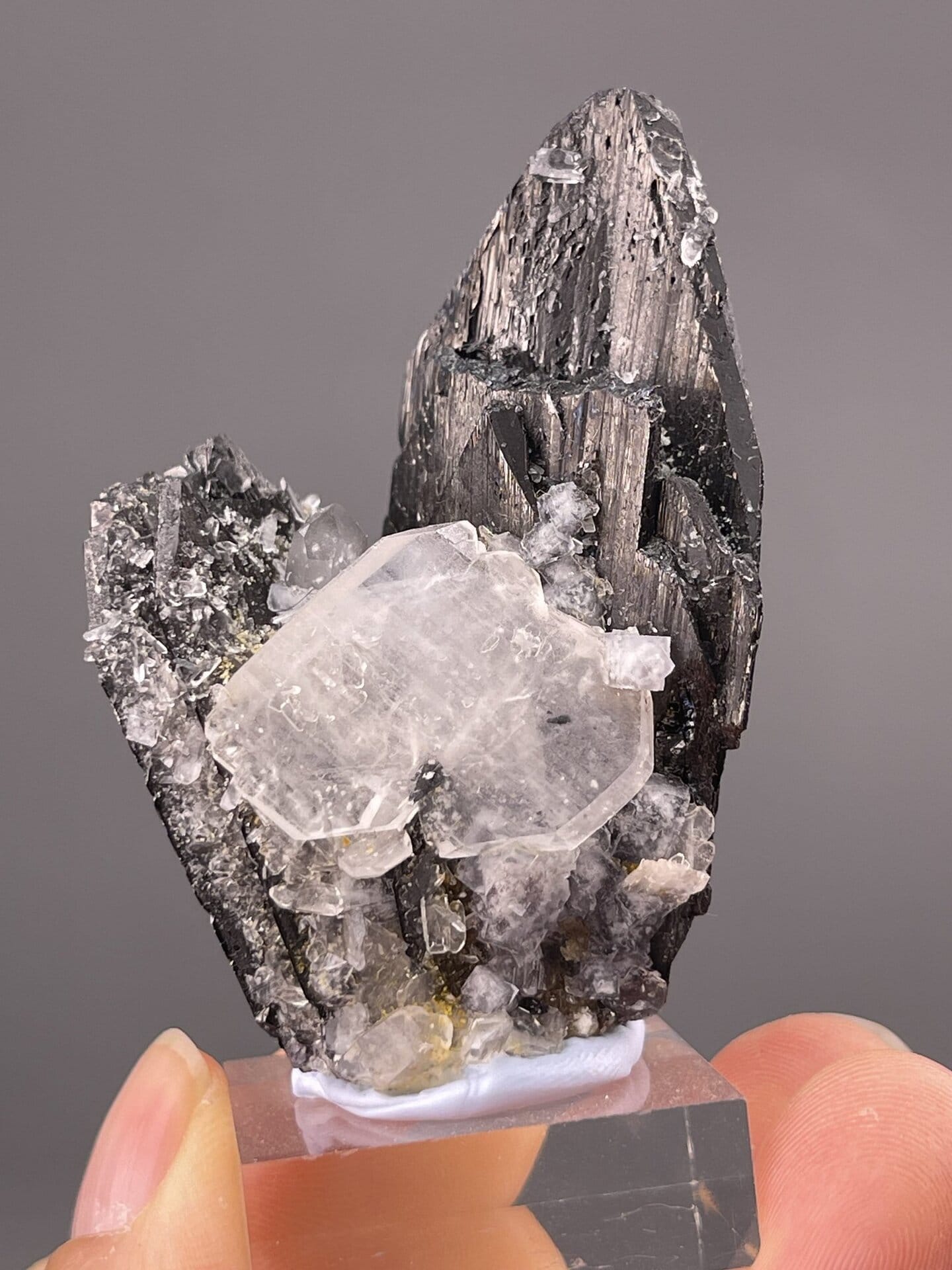Detail of cassiterite faces showing metallic sheen on white matrix