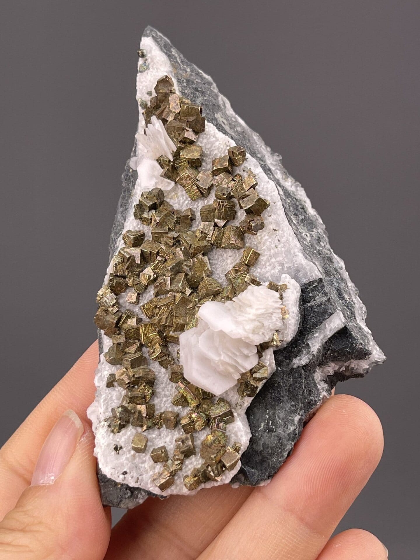 Close-up of pyrite crystals showing metallic luster on calcite