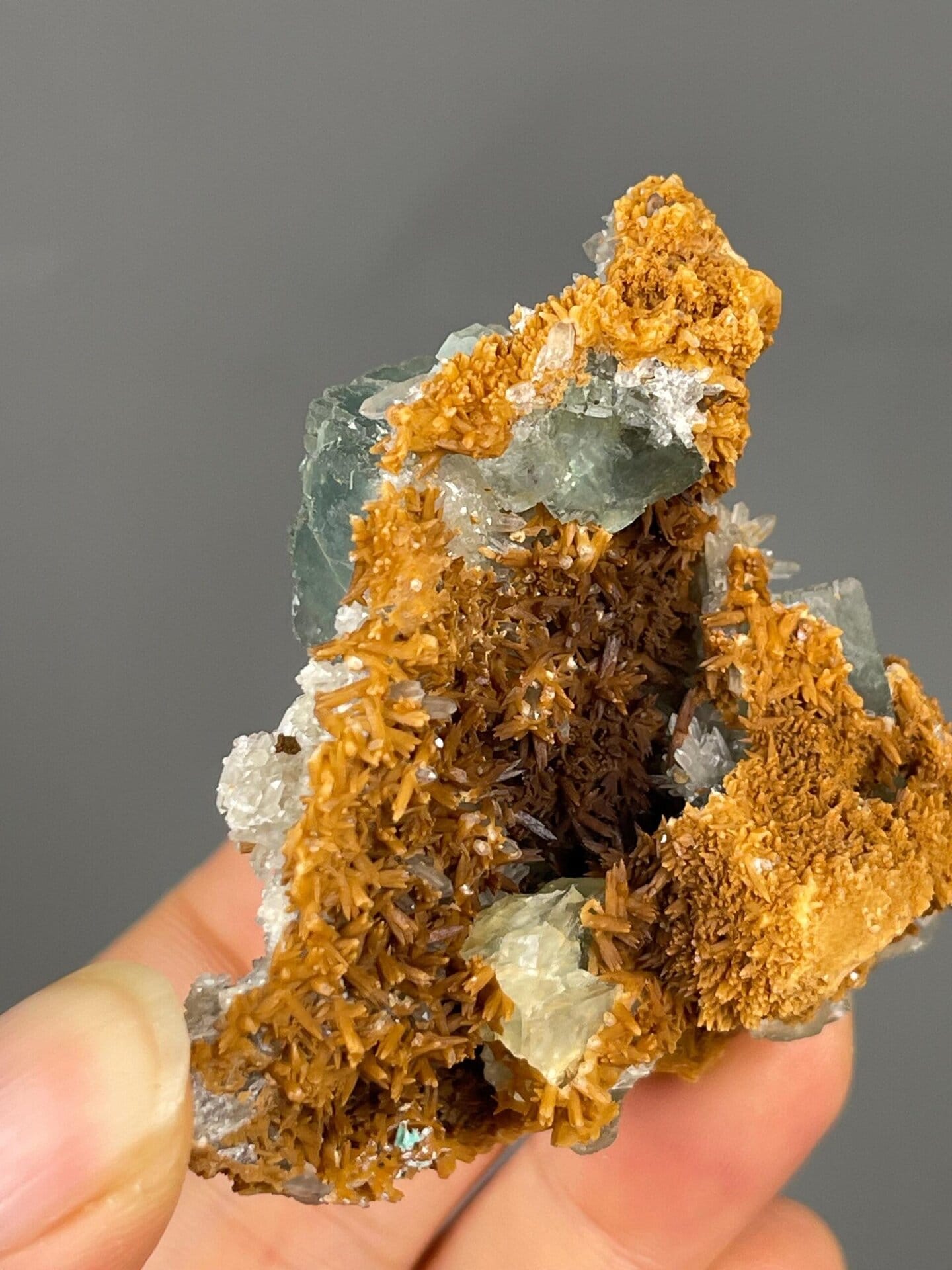 White calcite clusters alongside green fluorite cube