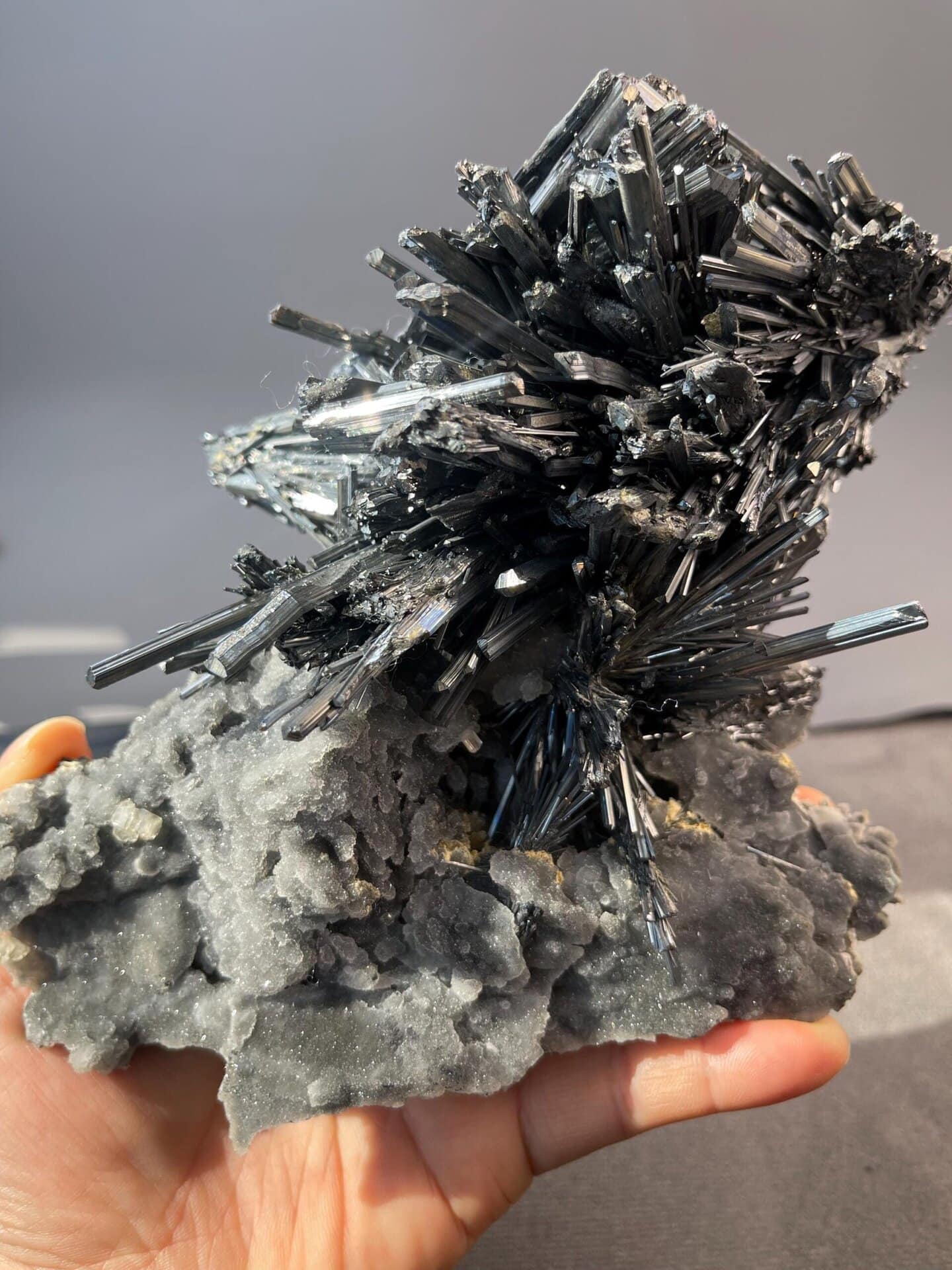 Metallic silver sheen on stibnite crystal surfaces