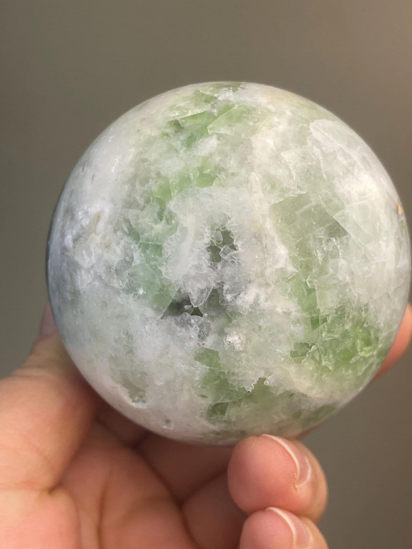 Polished green fluorite sphere with translucent interior