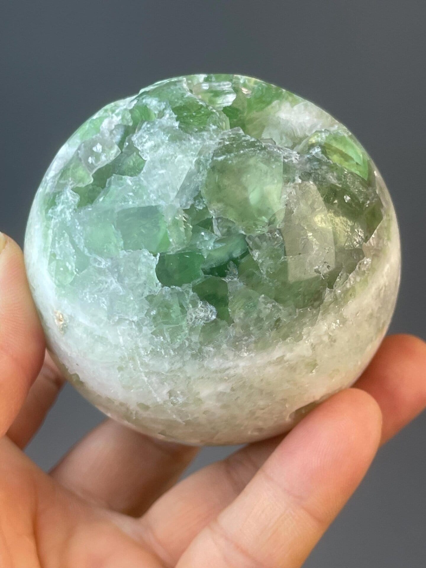 Green CaF₂ fluorite sphere with vitreous translucent luster