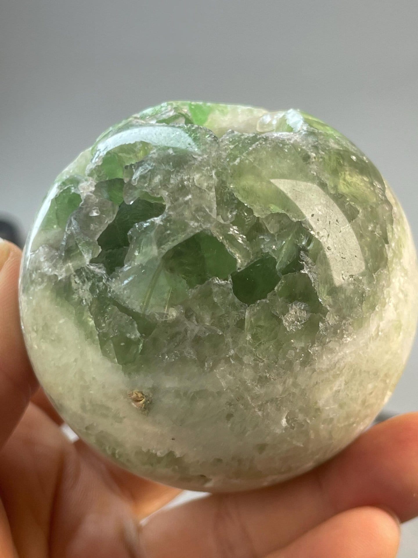 Artisan carved green fluorite sphere with natural inclusions