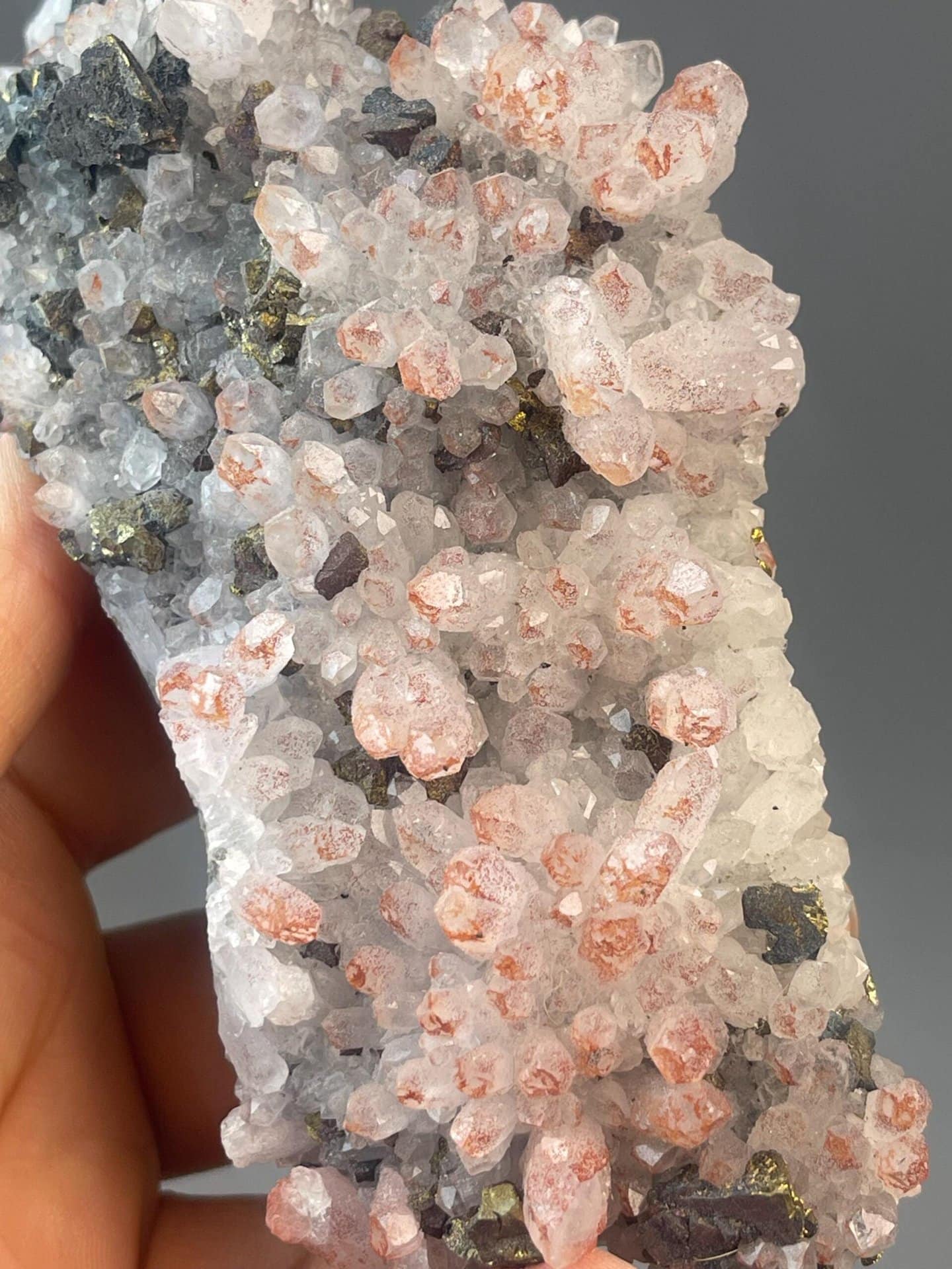 Red quartz crystal with trigonal habit on dark mineral matrix