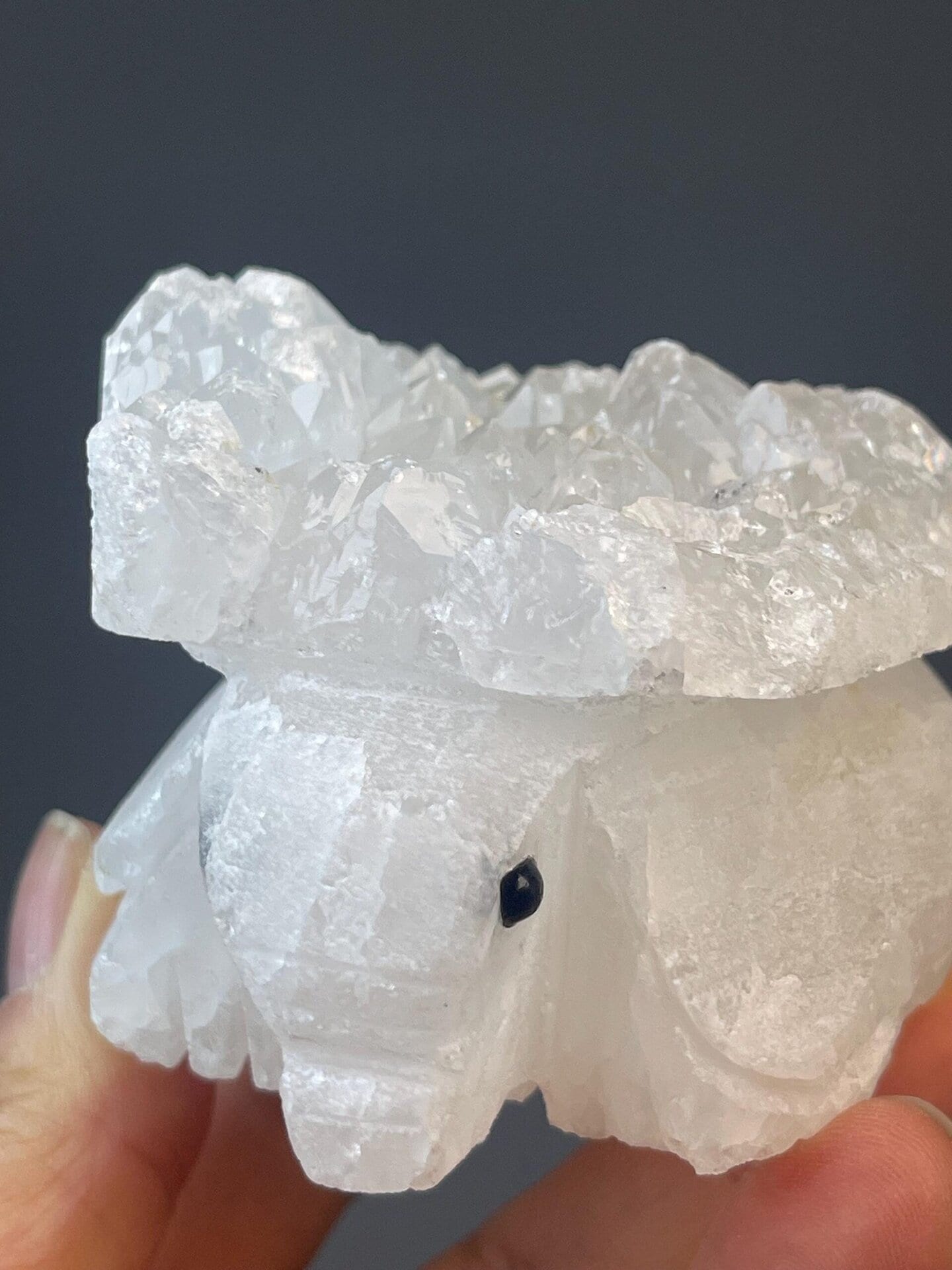 Quartz elephant carving with detailed surface and onyx eye stones