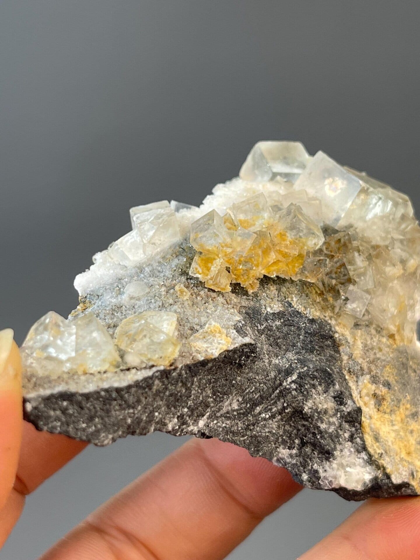 Rock matrix base supporting the fluorite cube