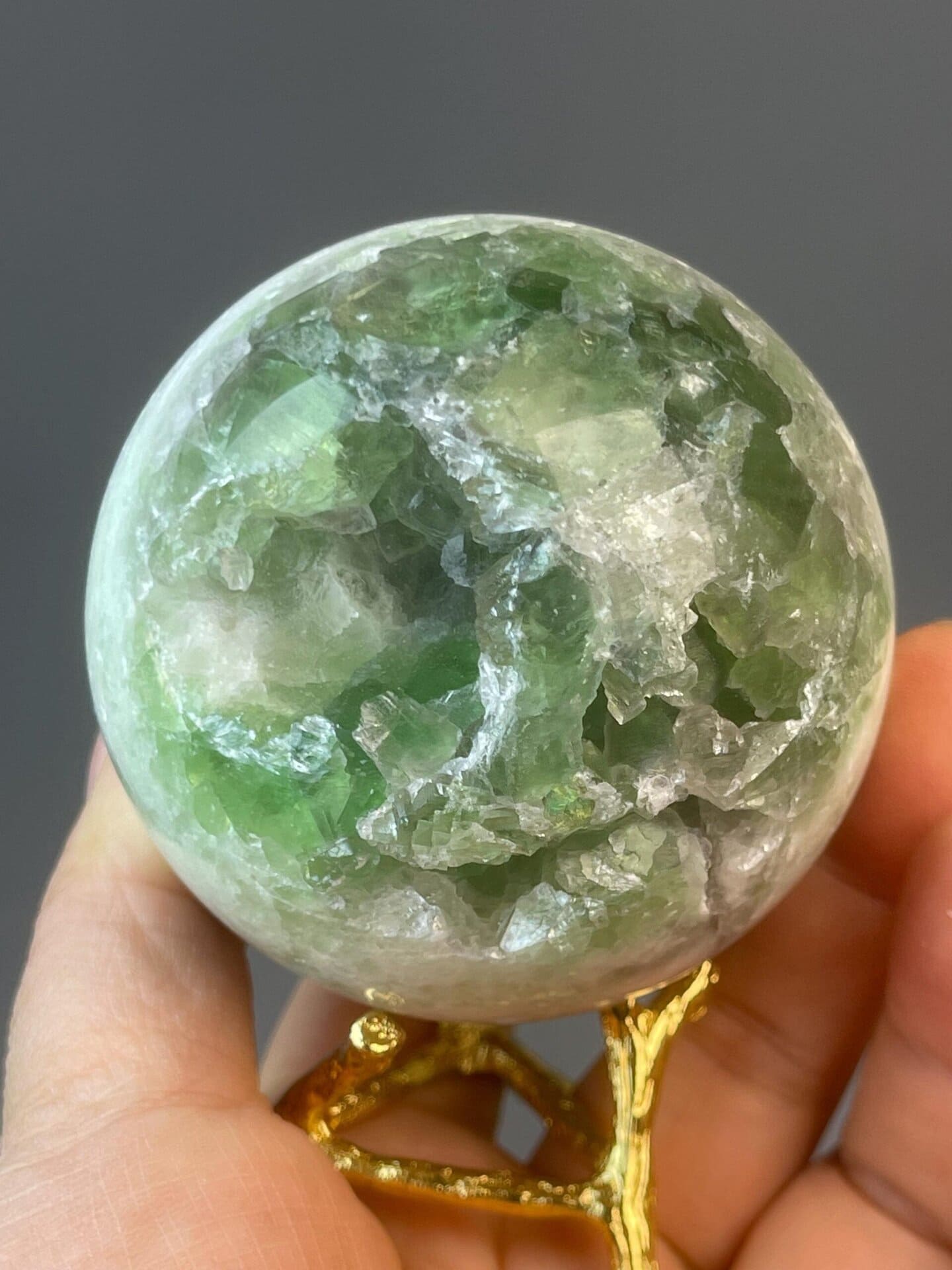 Green fluorite sphere with natural color patterns and banding