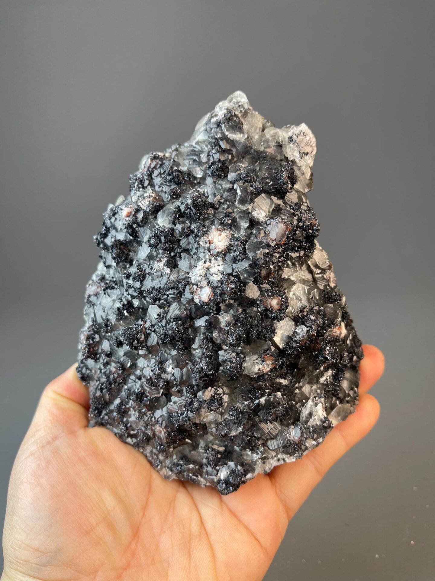 Gray hematite with vivid red secondary layer and calcite accents