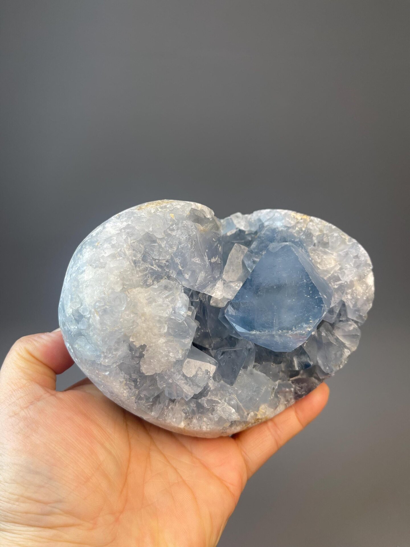 Collector carved celestite heart from Madagascar mineral deposit