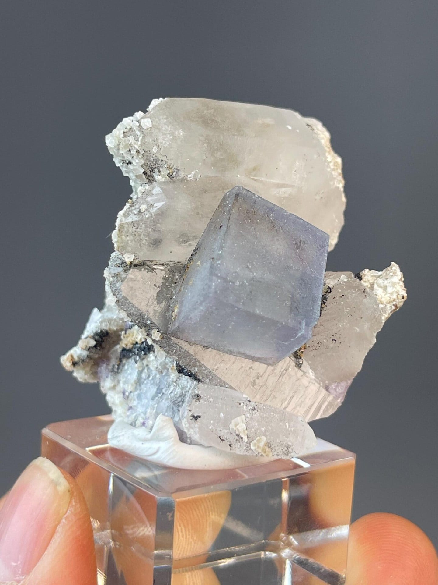 Transparent blue fluorite cube with white quartz crystal pillars