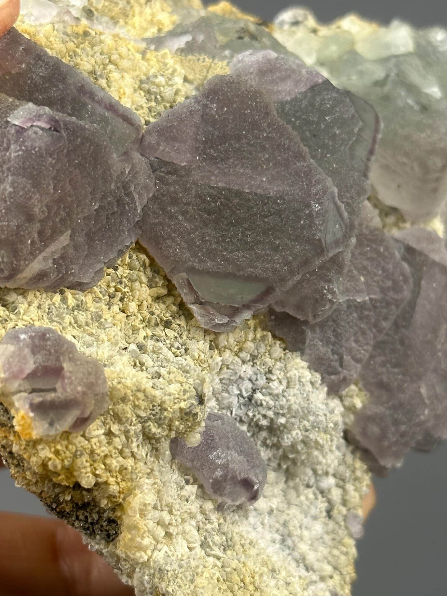 Angled view of large purple fluorite cluster on base rock