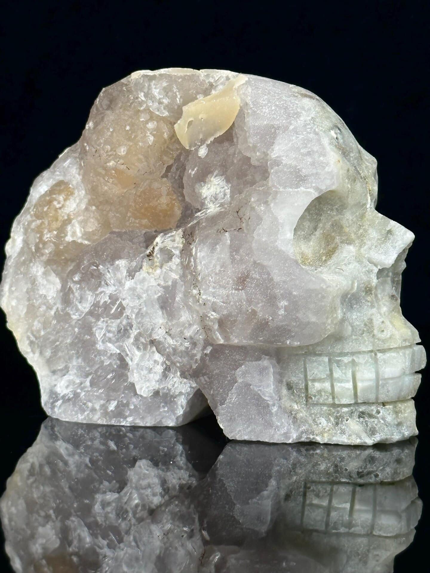 Side profile of large quartz geode skull showing crystal interior