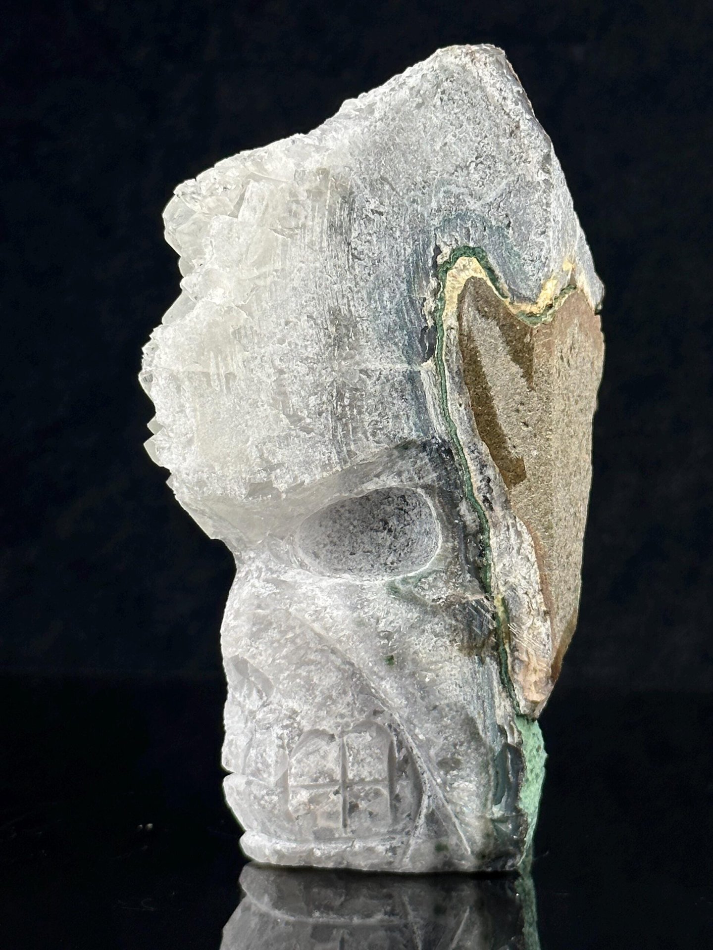 Hand-carved quartz geode skull with malachite accents, front view