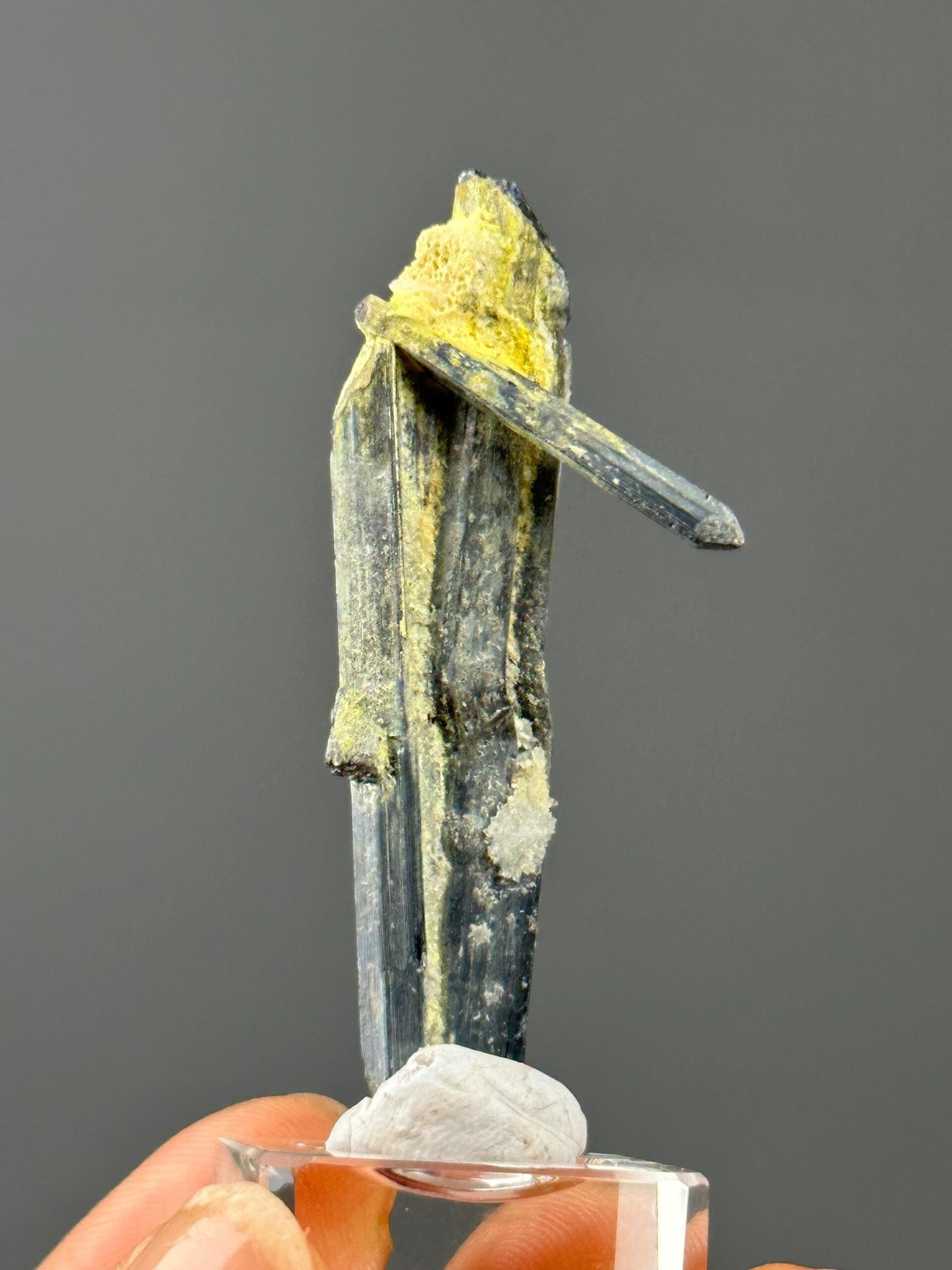 Close-up of stibnite surface showing metallic luster and striations