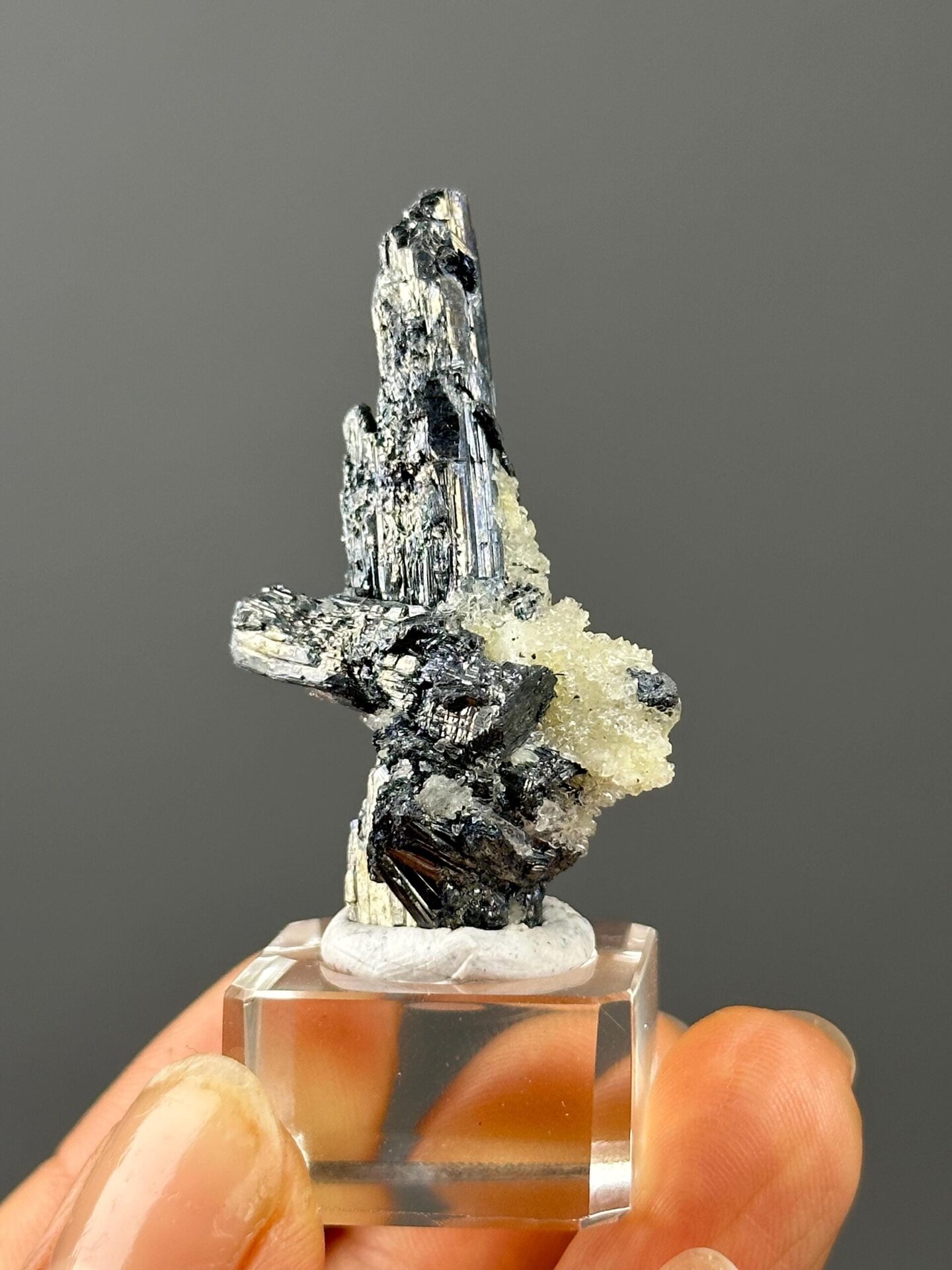 Detail of stibnite crystal surface and barite matrix interface