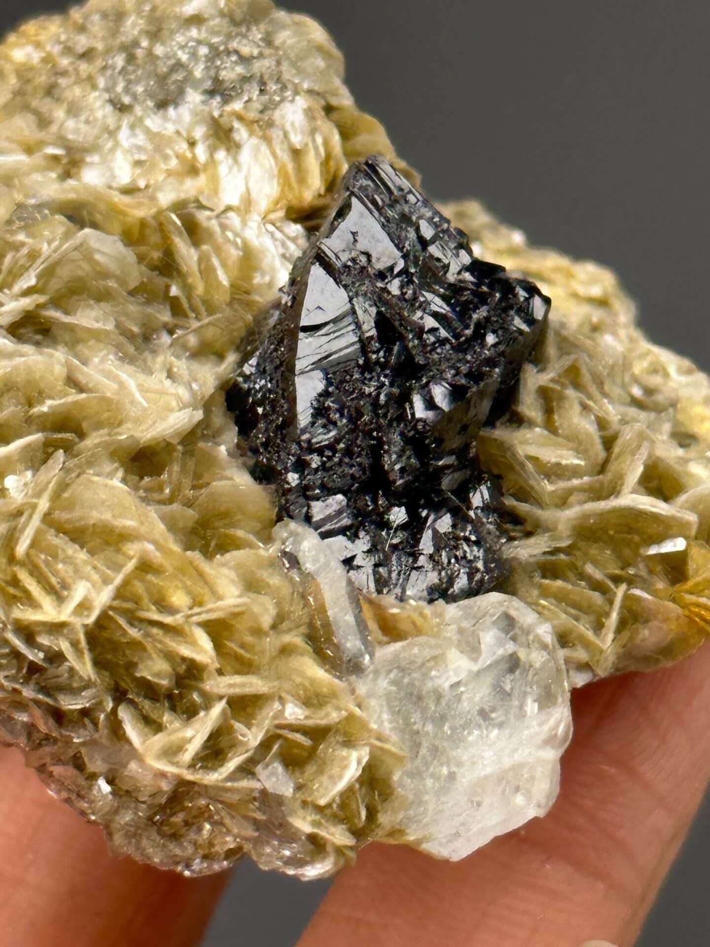 Front view of cassiterite cluster with aquamarine inclusion