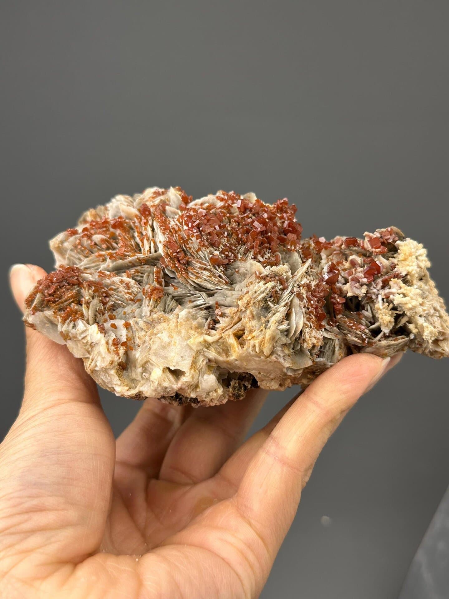 Angled view highlighting red vanadinite against white barite