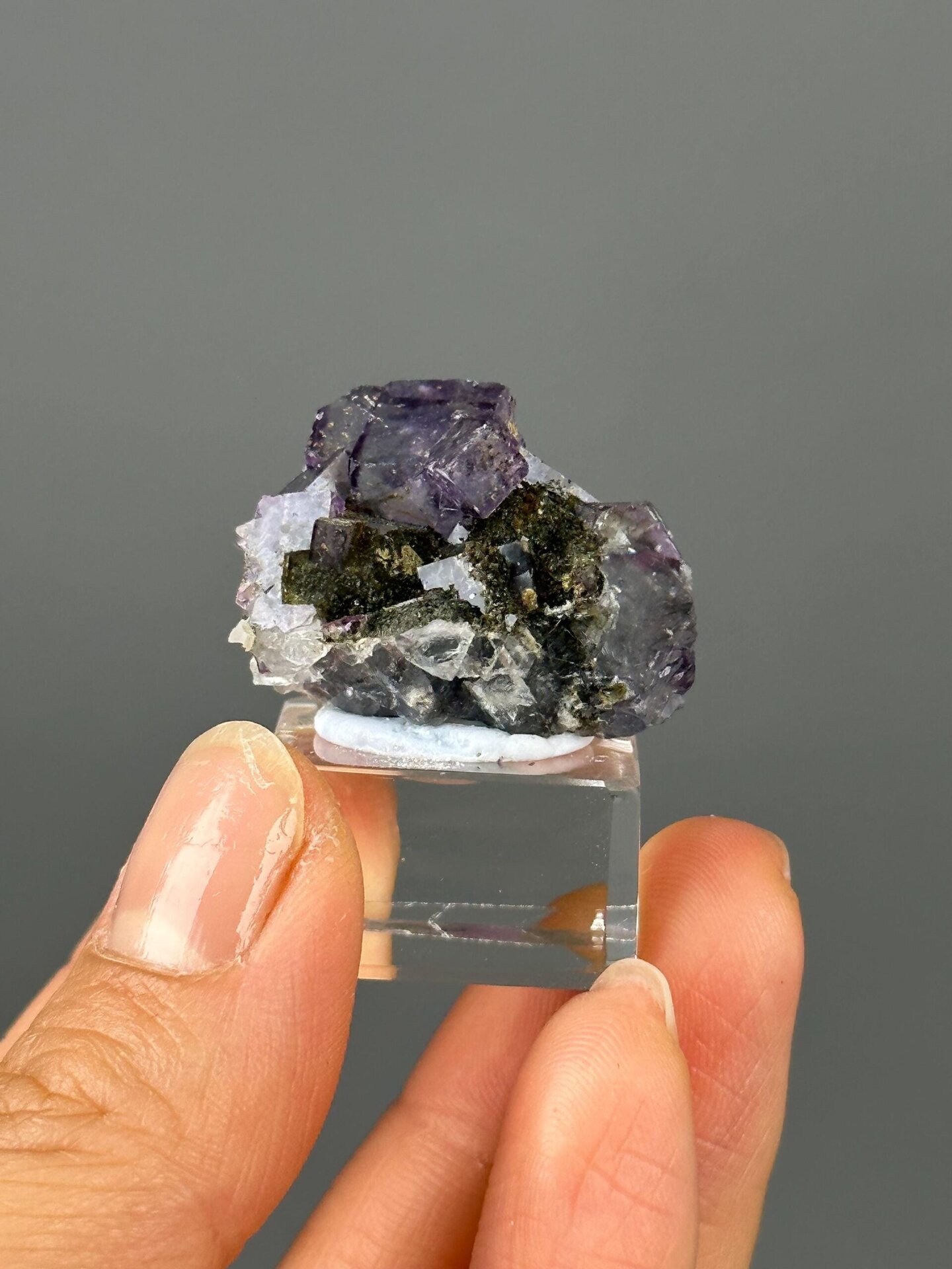 Green epidote inclusions inside transparent fluorite close-up