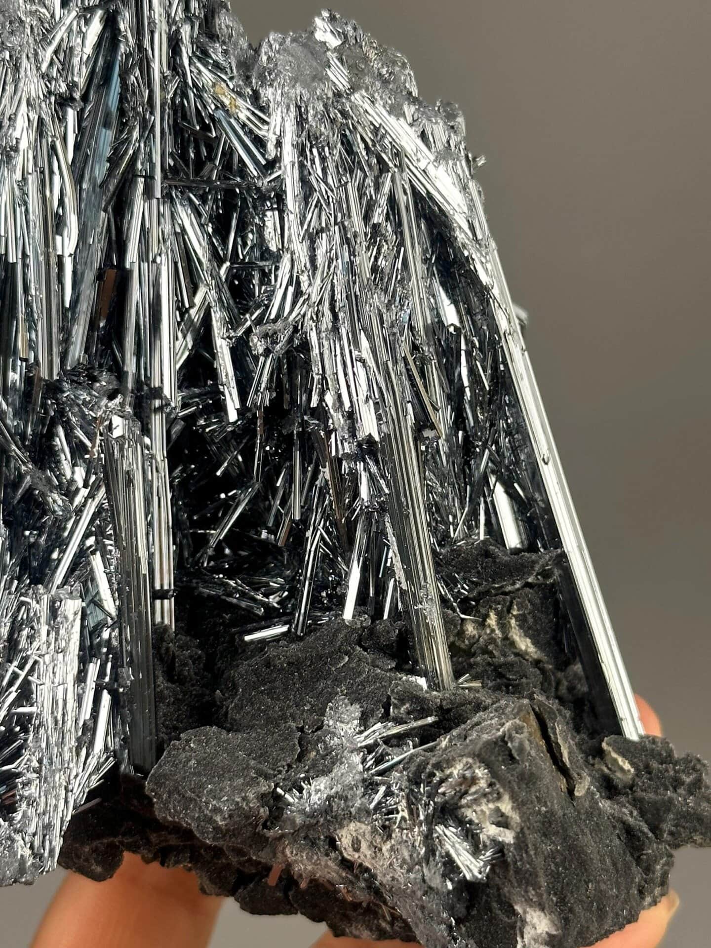 Silvery metallic luster on stibnite crystal needles