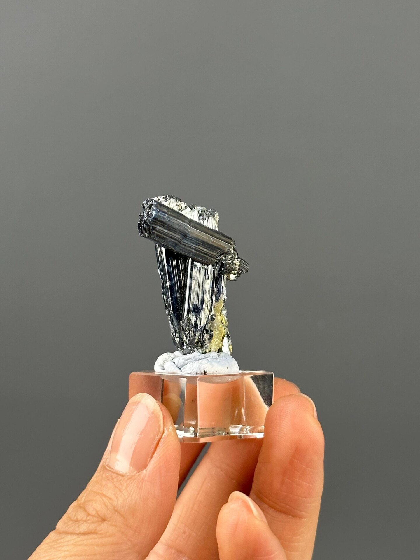Silver metallic sheen on stibnite twin blades
