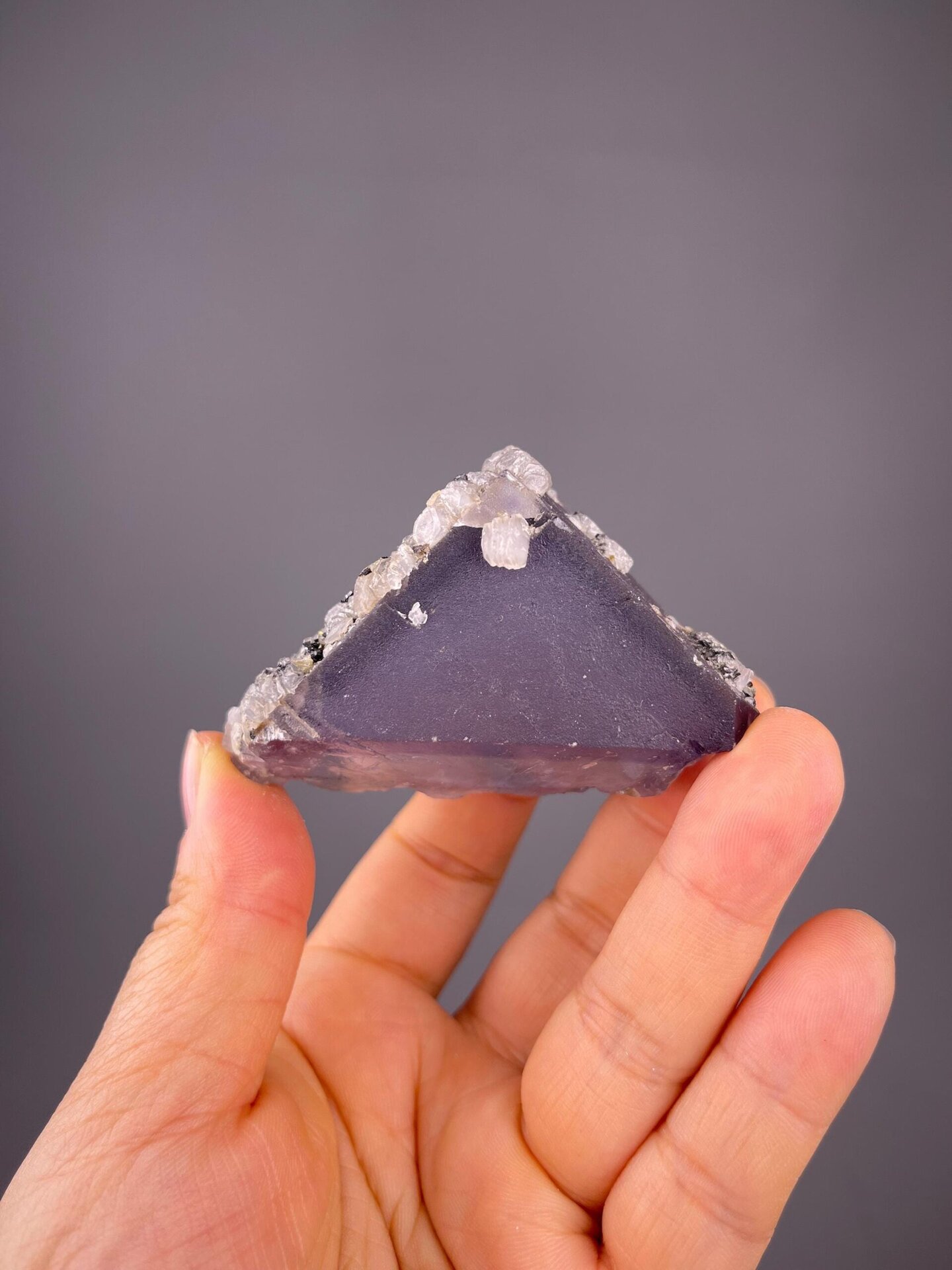 Side view of purple fluorite with white calcite encrustation
