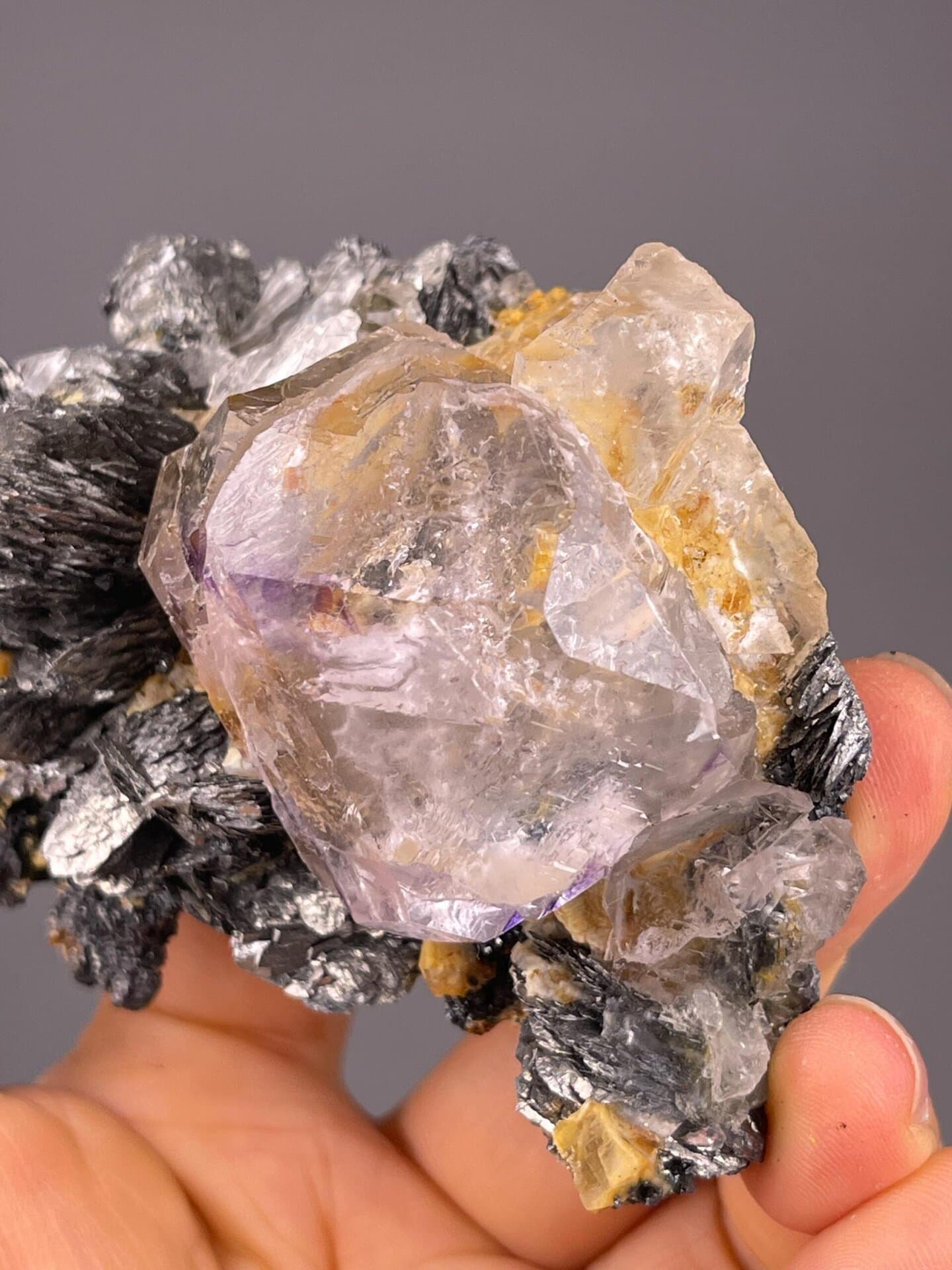Clear fluorite with internal purple phantoms and marcasite blades
