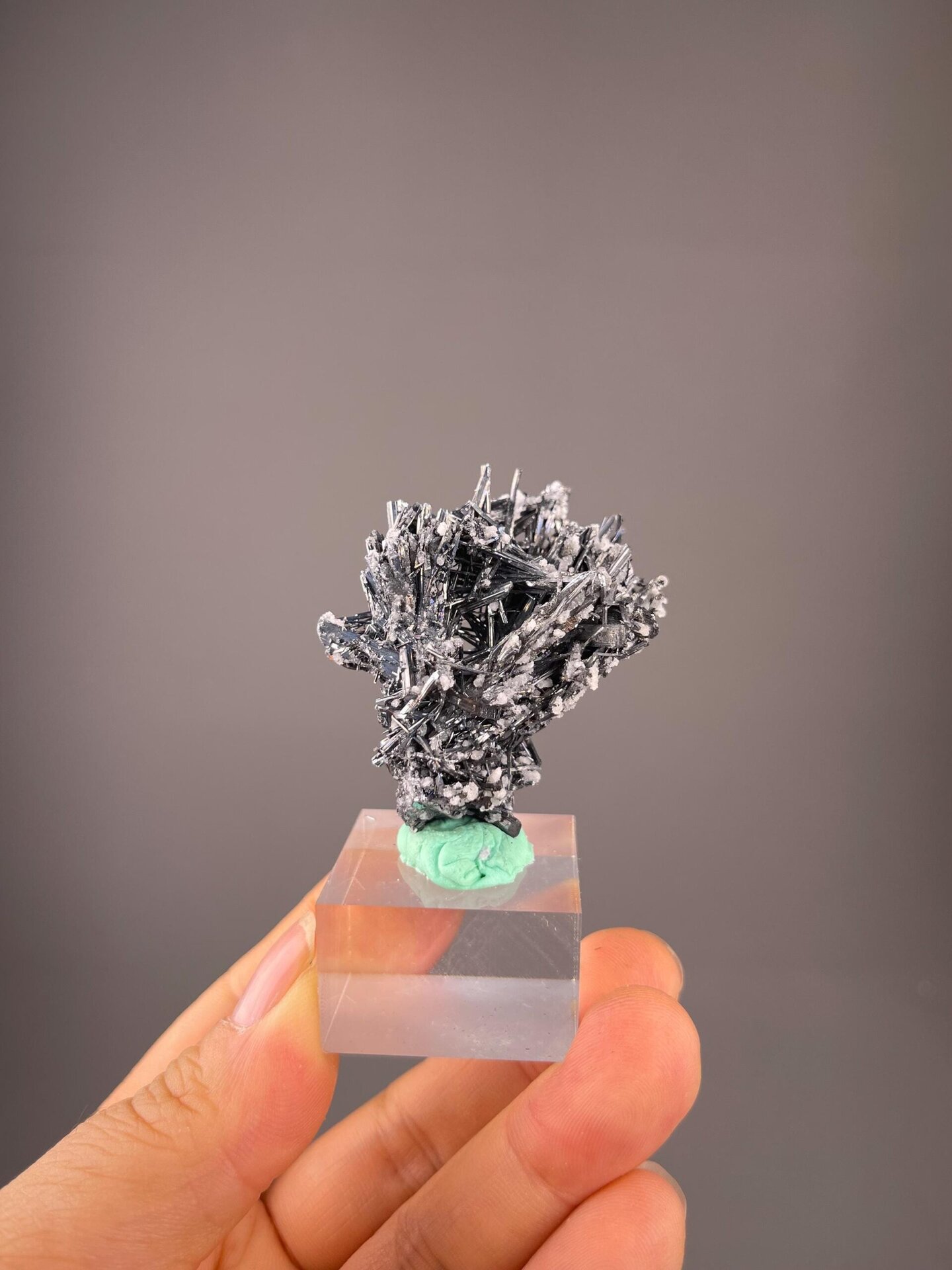 Metallic gray stibnite prismatic crystal with white calcite