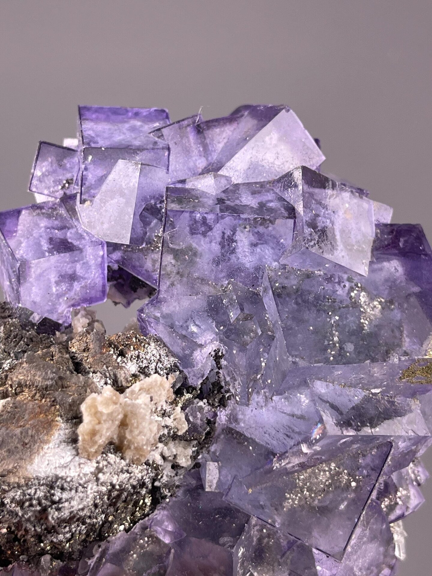 Purple fluorite phantom cluster with associated pyrite crystals