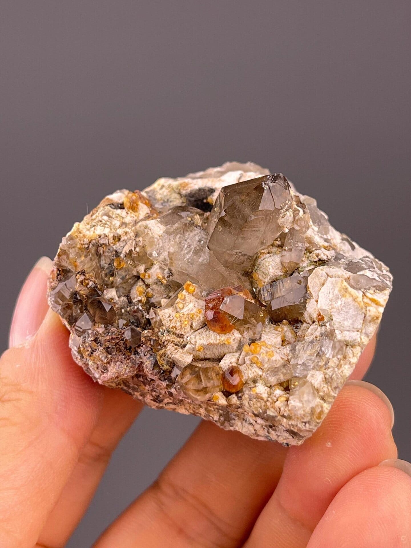 Reddish garnet with smoky quartz and creamy dolomite rhombs