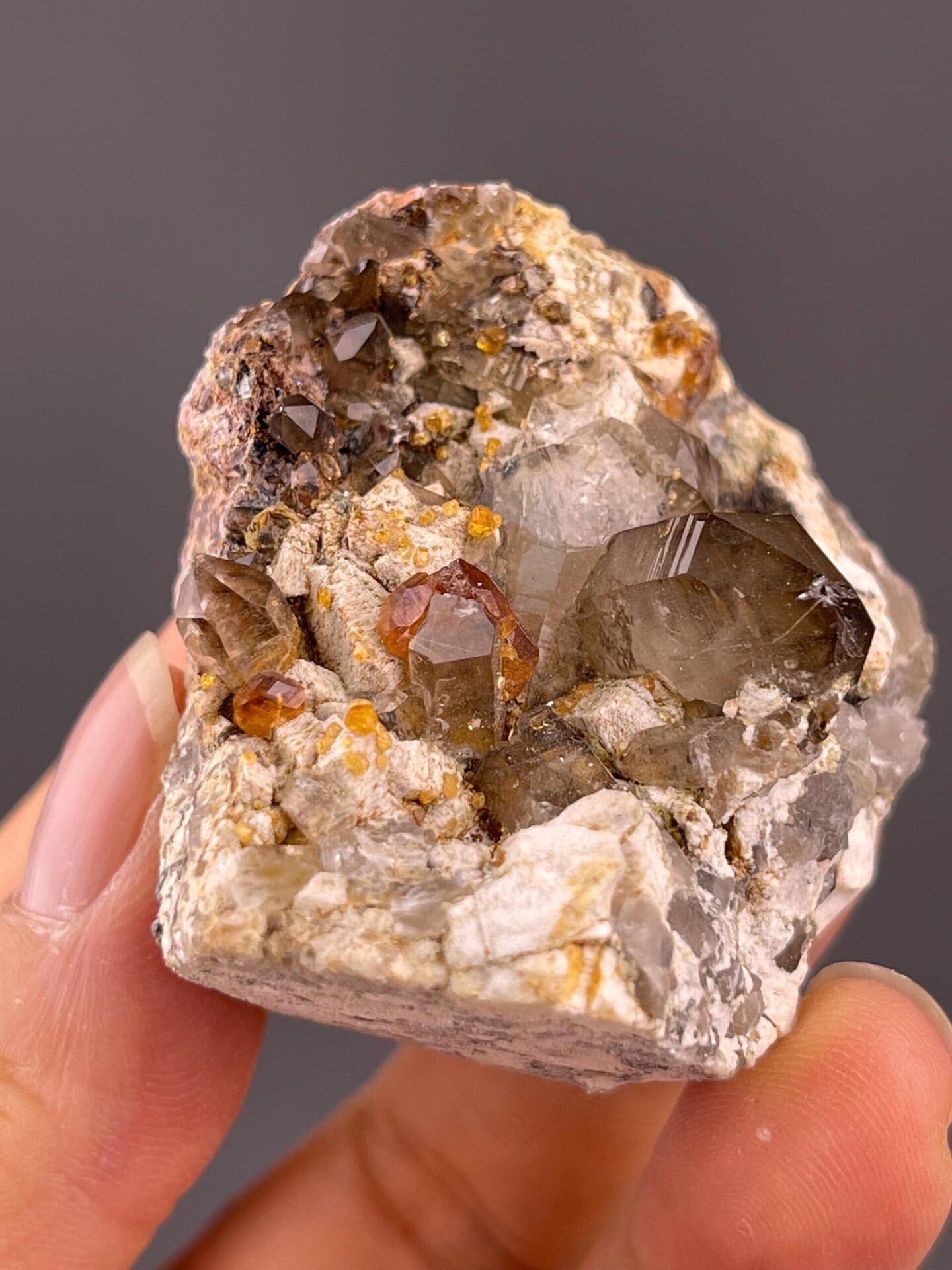Natural mineral trio: smoky quartz, garnet, and dolomite