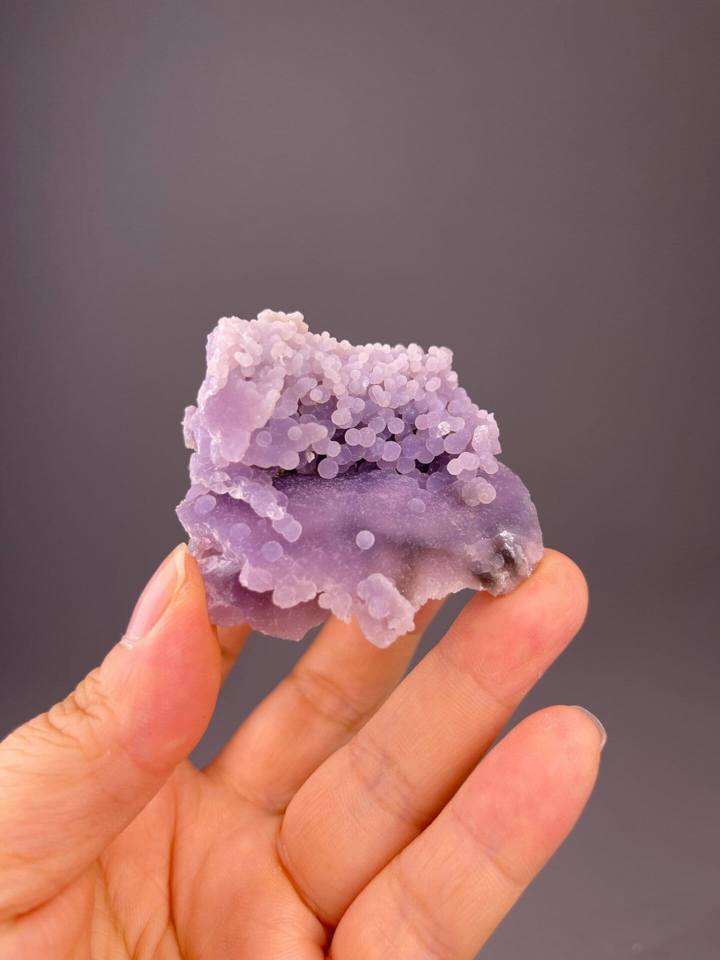 Close-up of purple grape agate spheroids showing waxy luster