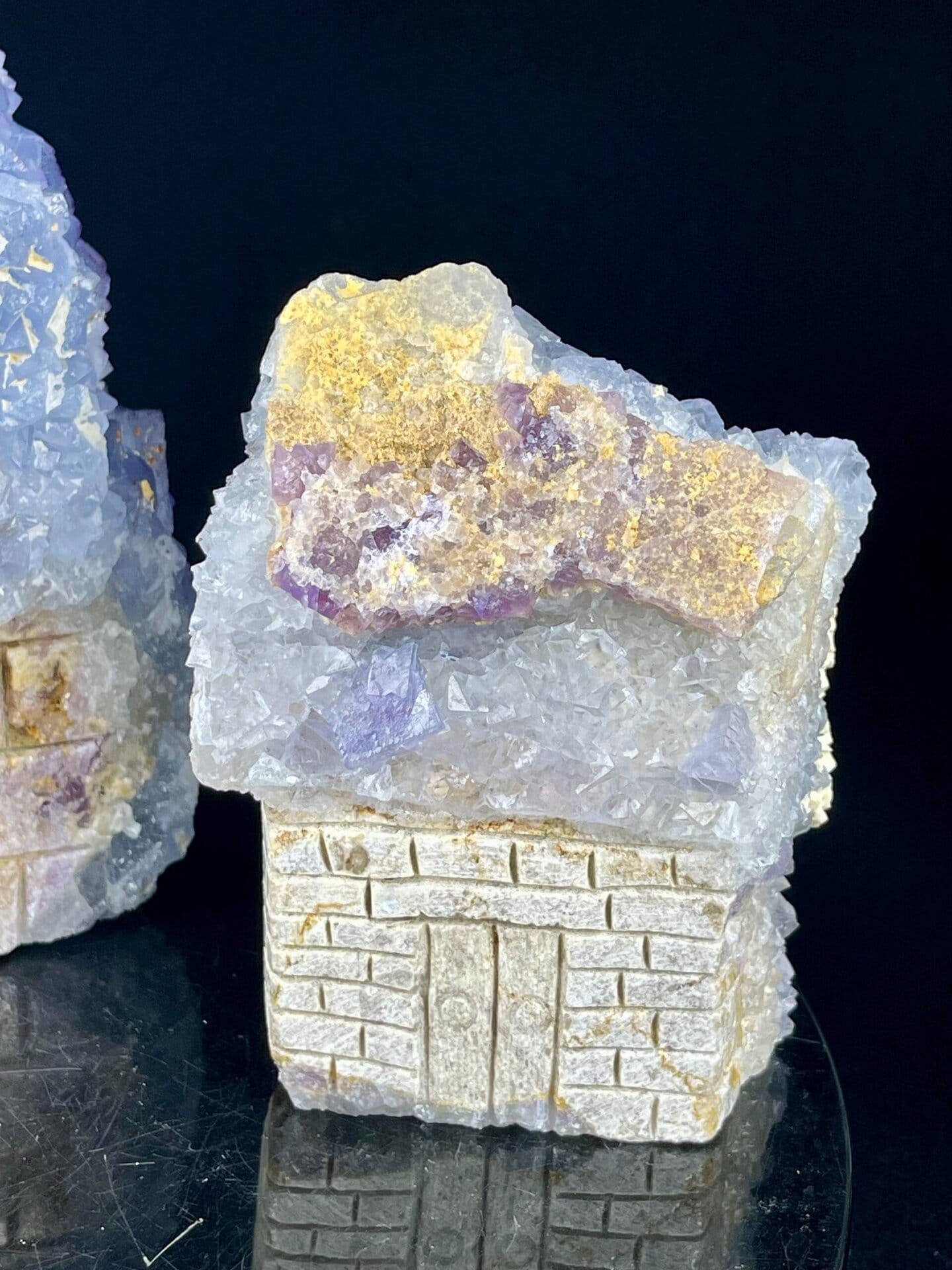 Side view of carved calcite house set with natural colors