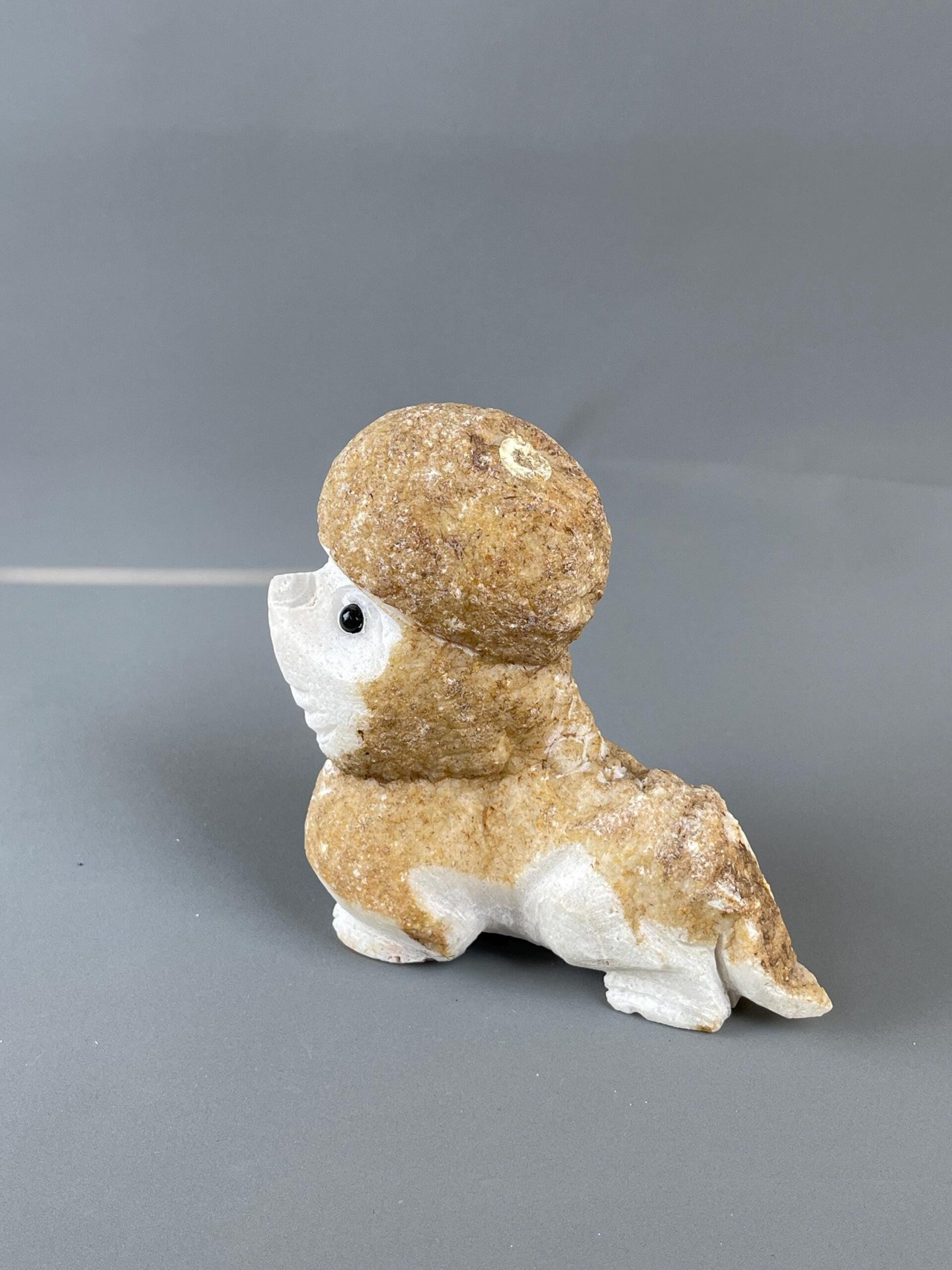 Close-up of black onyx eyes on hand-carved stone poodle