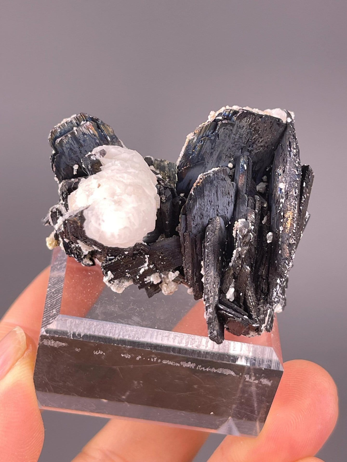 Tetragonal cassiterite beside fluorescent calcite matrix