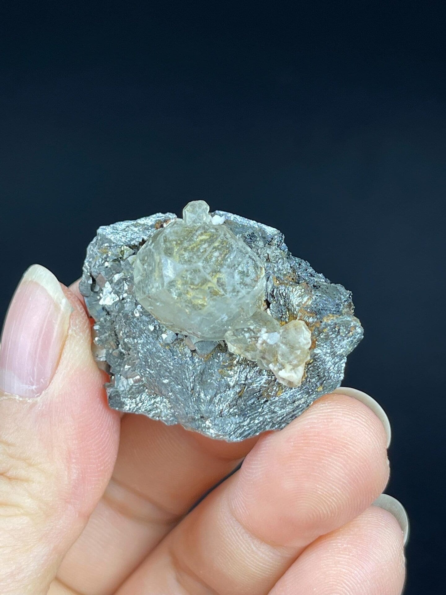 Transparent fluorite sphere perched on iron ore matrix