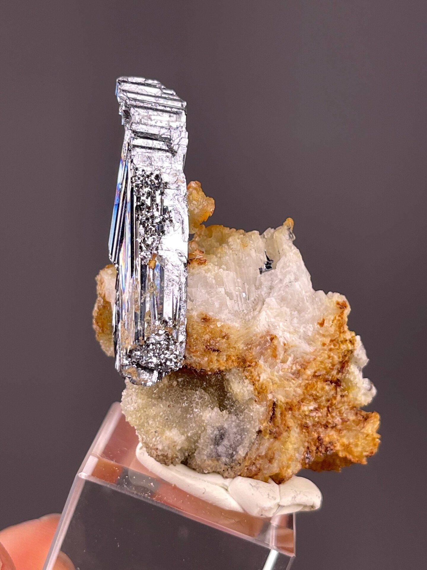 Sharp prismatic stibnite blade on natural rock matrix