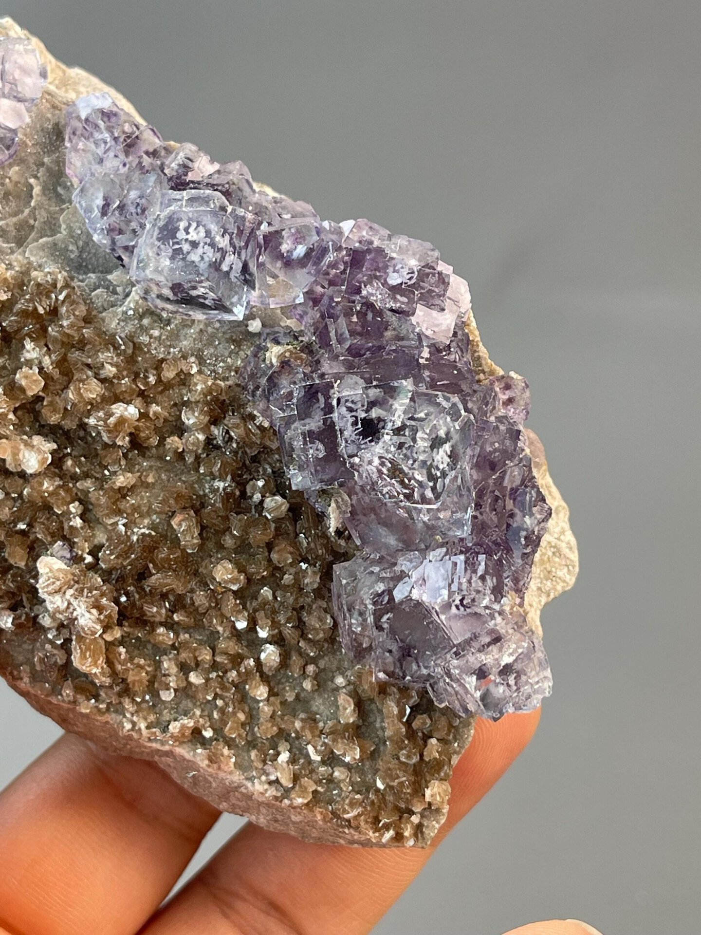 Close-up of purple phantom zones in fluorite with mica base