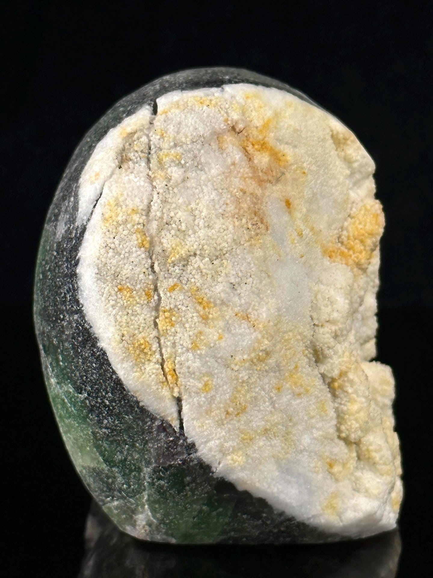 Artisan-carved fluorite skull with natural coloration and geode