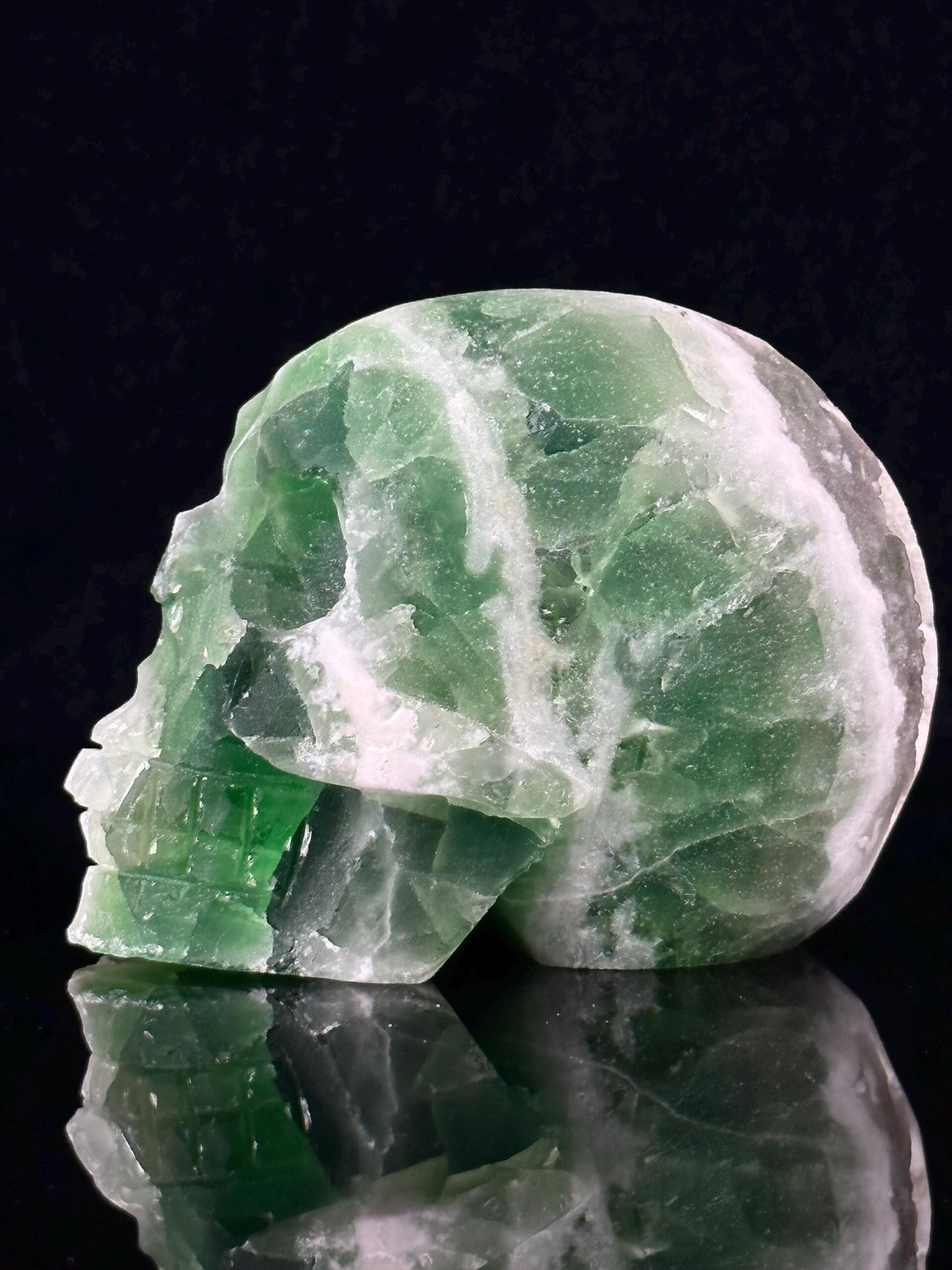 Front view of carved green and white fluorite skull