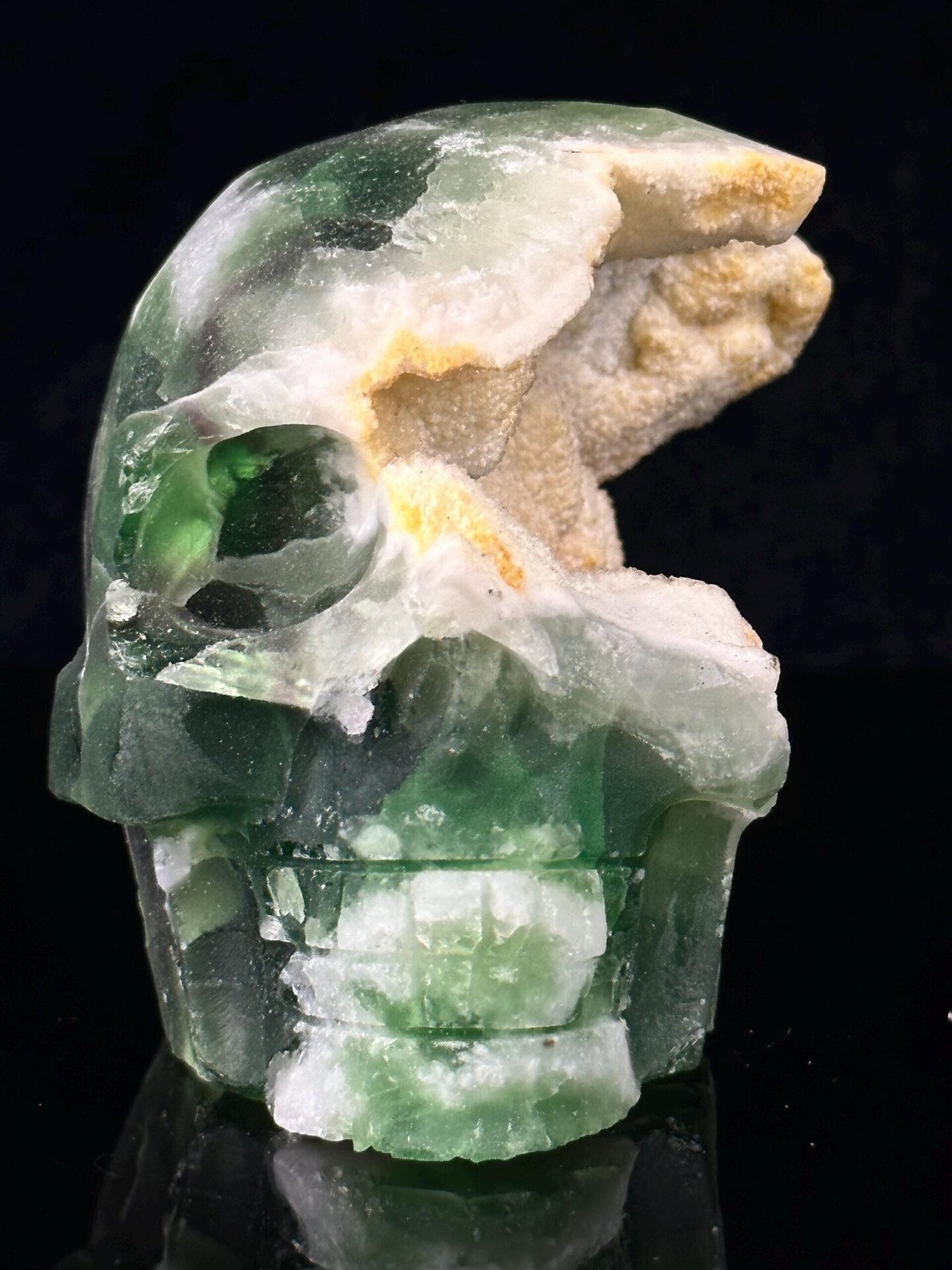 Hand-carved green fluorite skull with geode crystal interior