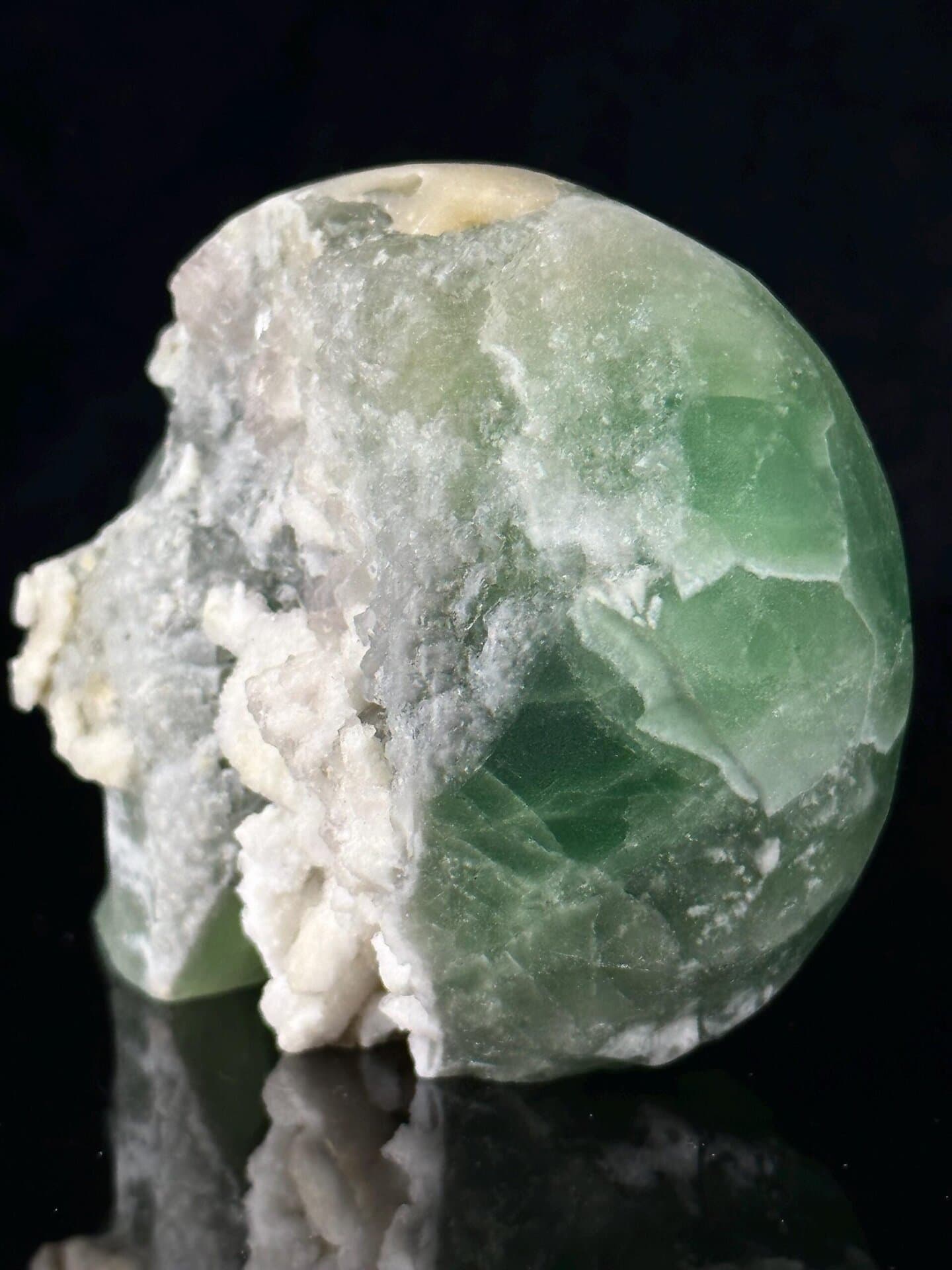 Green and white fluorite banding on carved skull face
