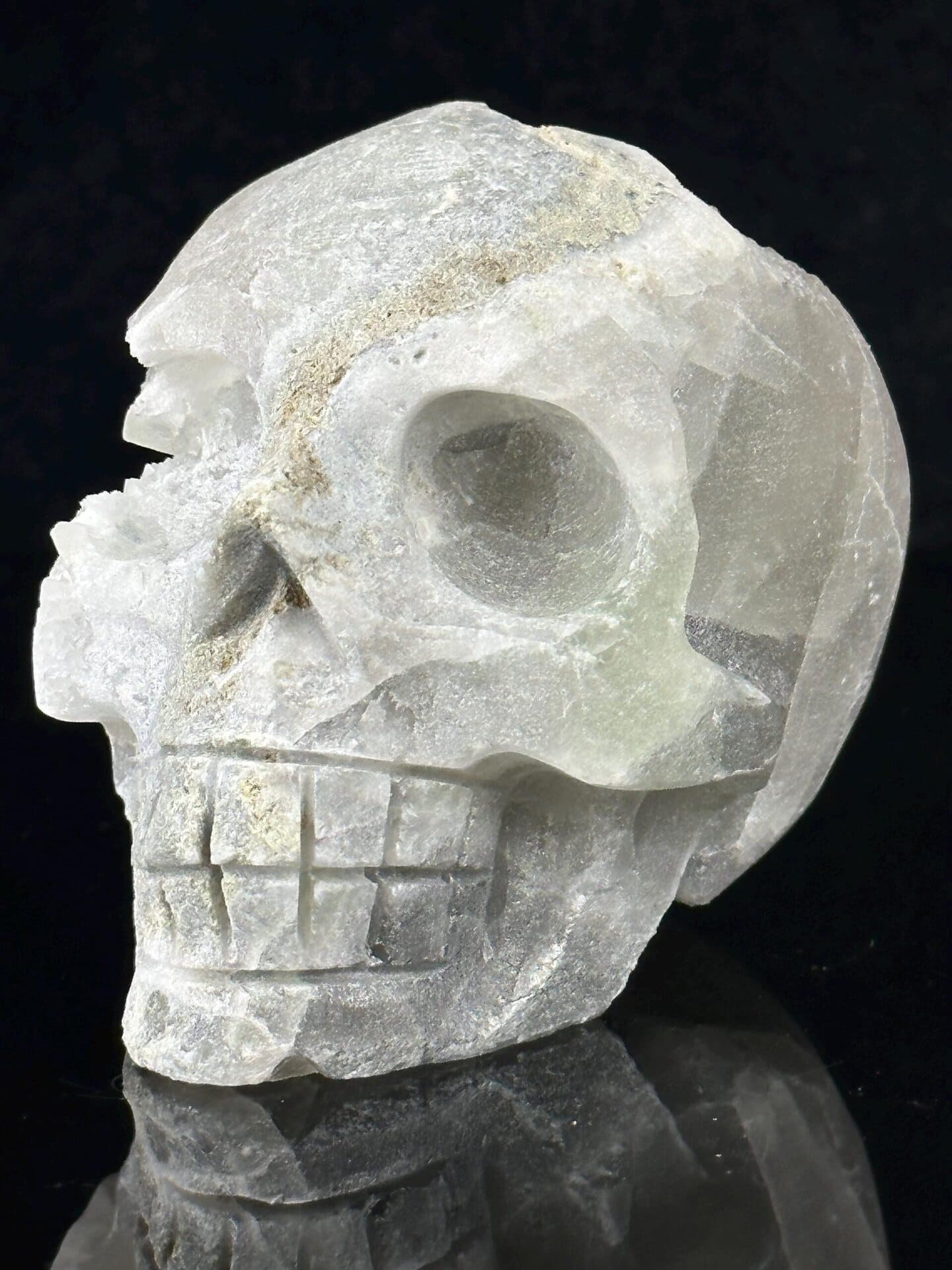 Hand-carved fluorite skull with natural quartz geode interior