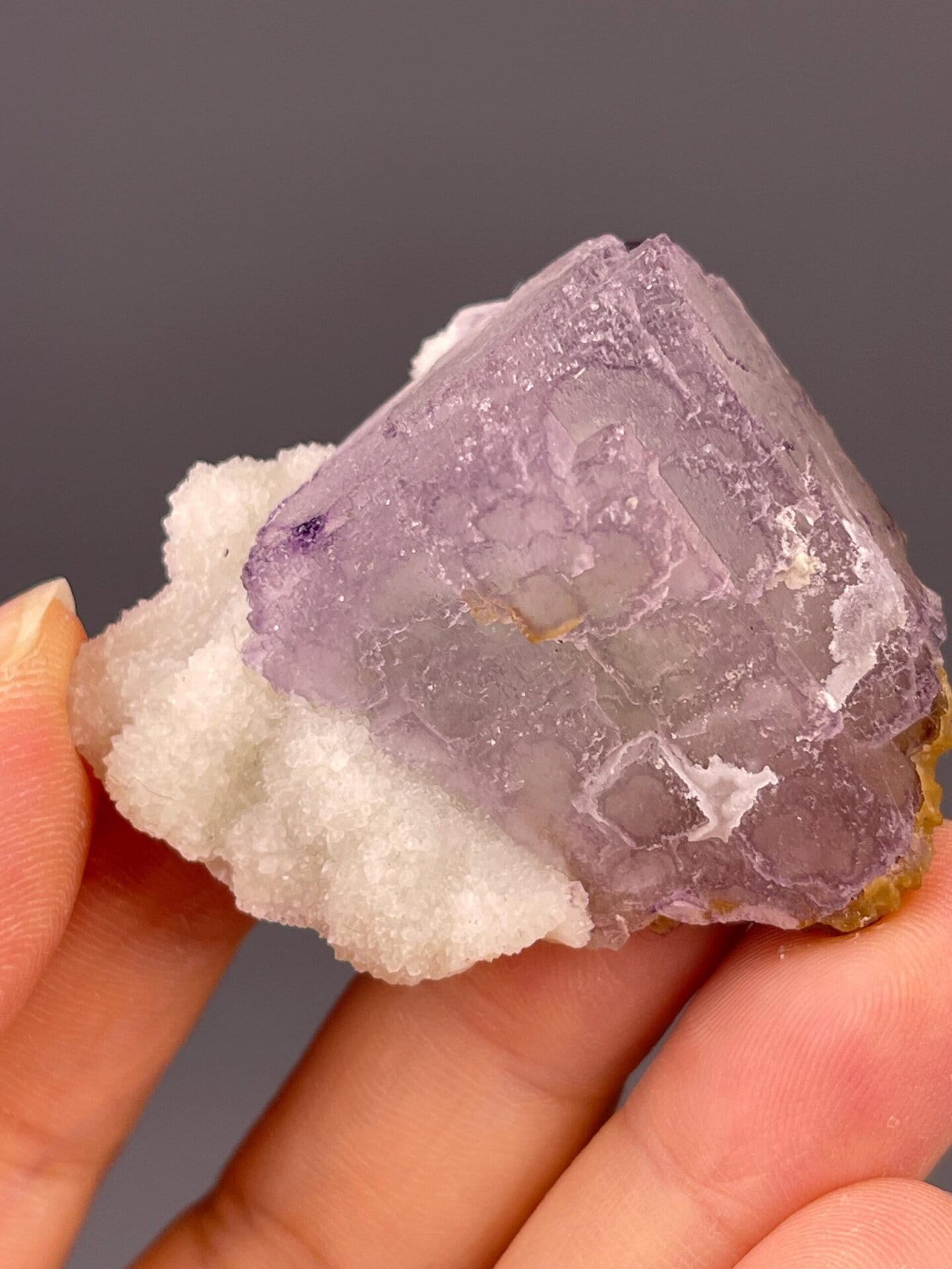 Angled view of purple fluorite cube showing QR-code formation