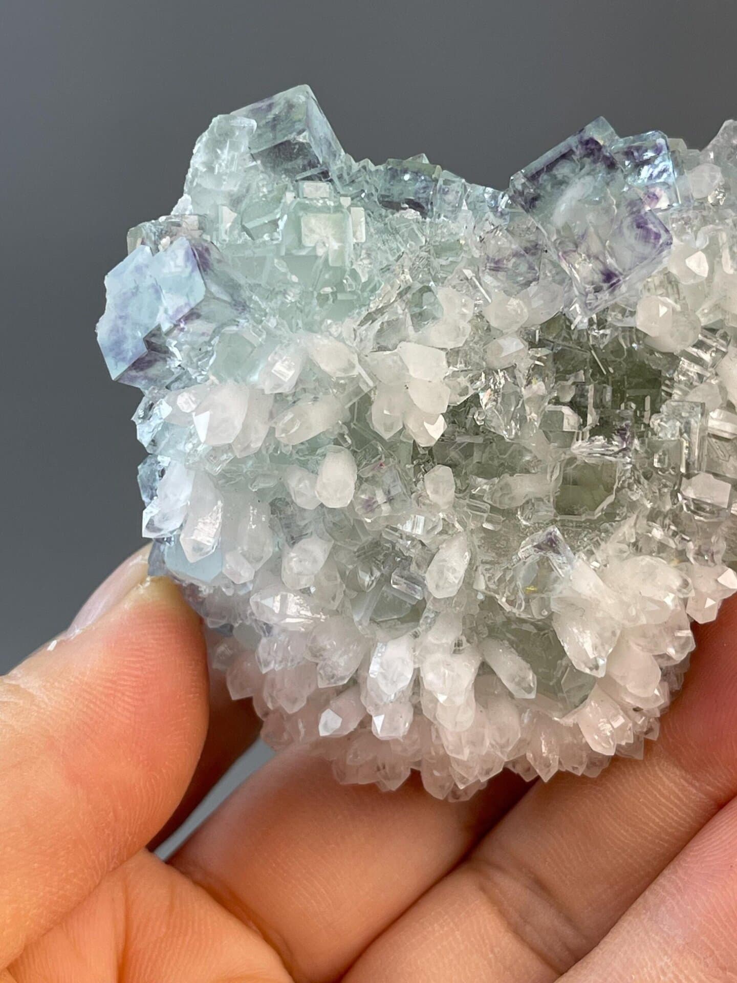 Close-up of alternating green and purple fluorite cube faces