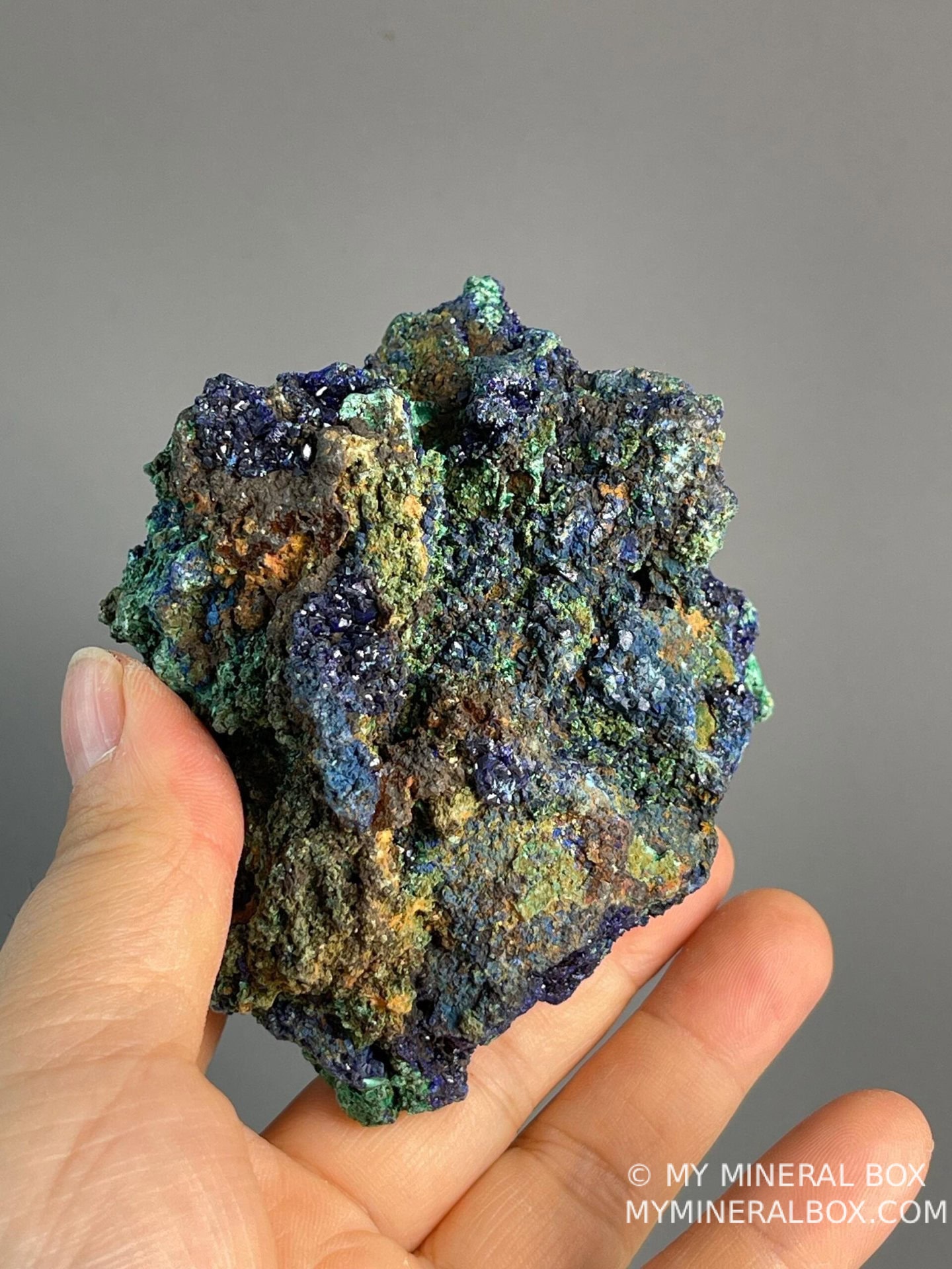 Iridescent light-catching azurite crystals beside malachite