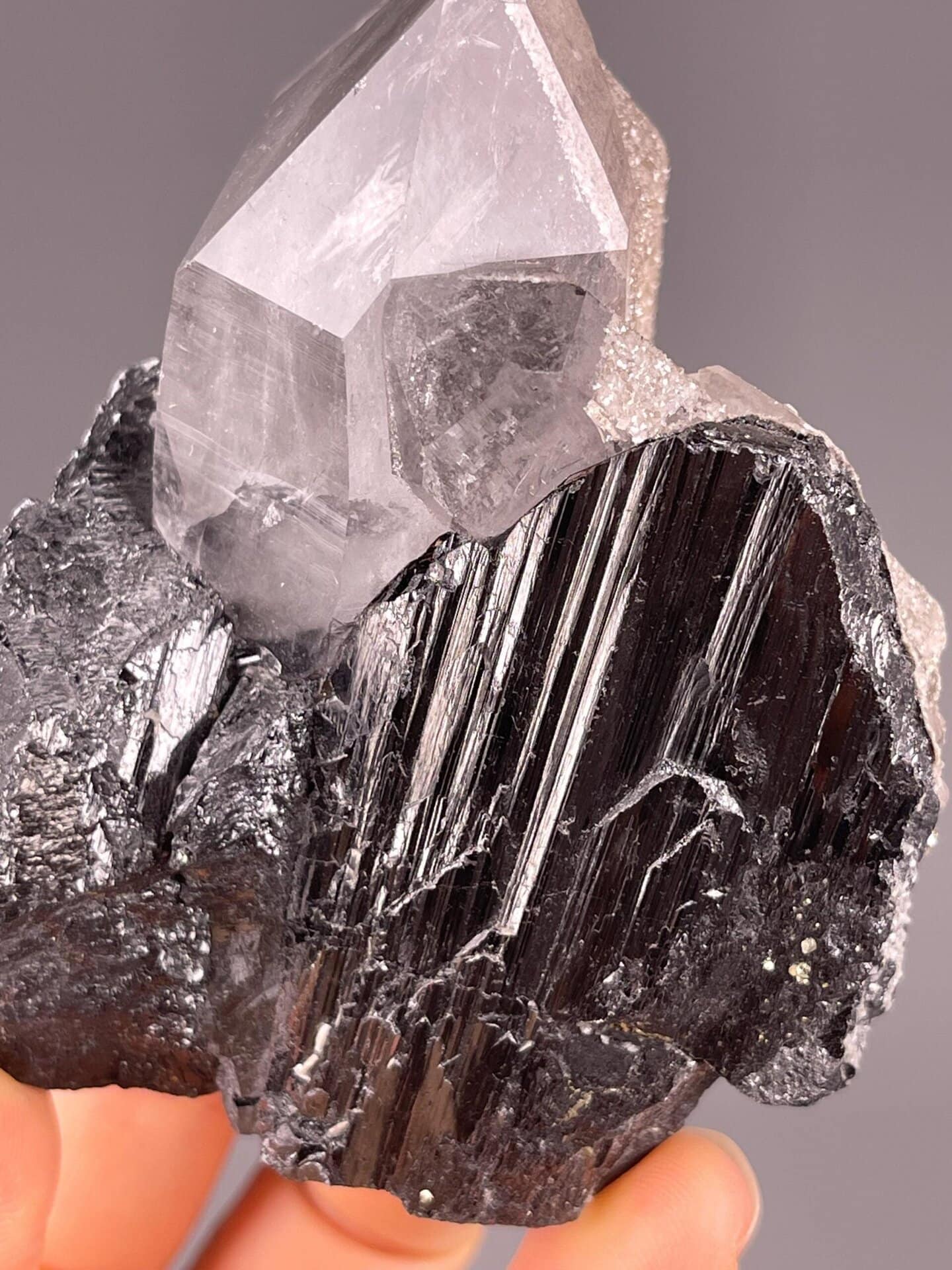 Metallic-black cassiterite beside clear quartz crystal