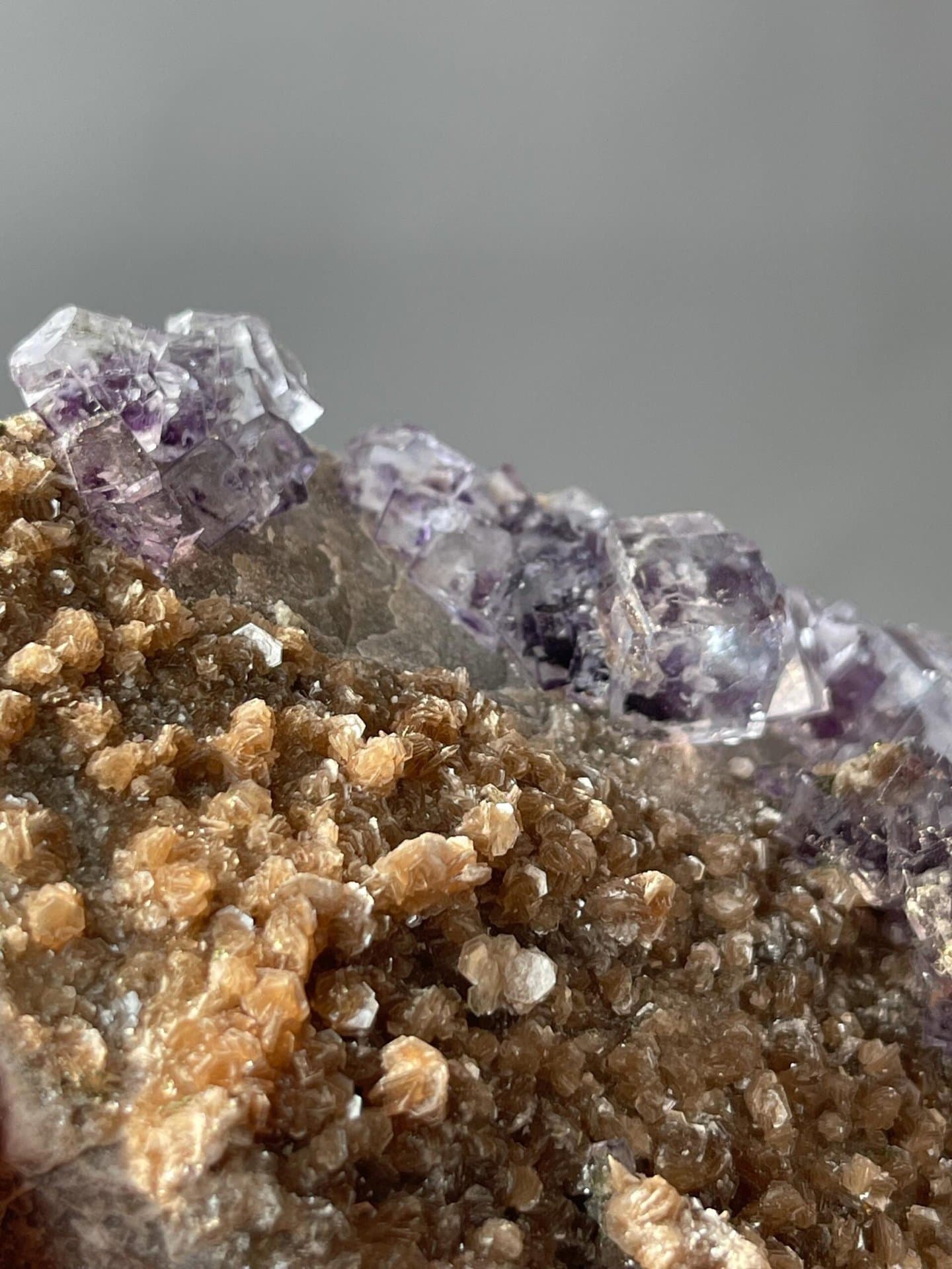 Purple phantom fluorite with mica base displaying vitreous luster