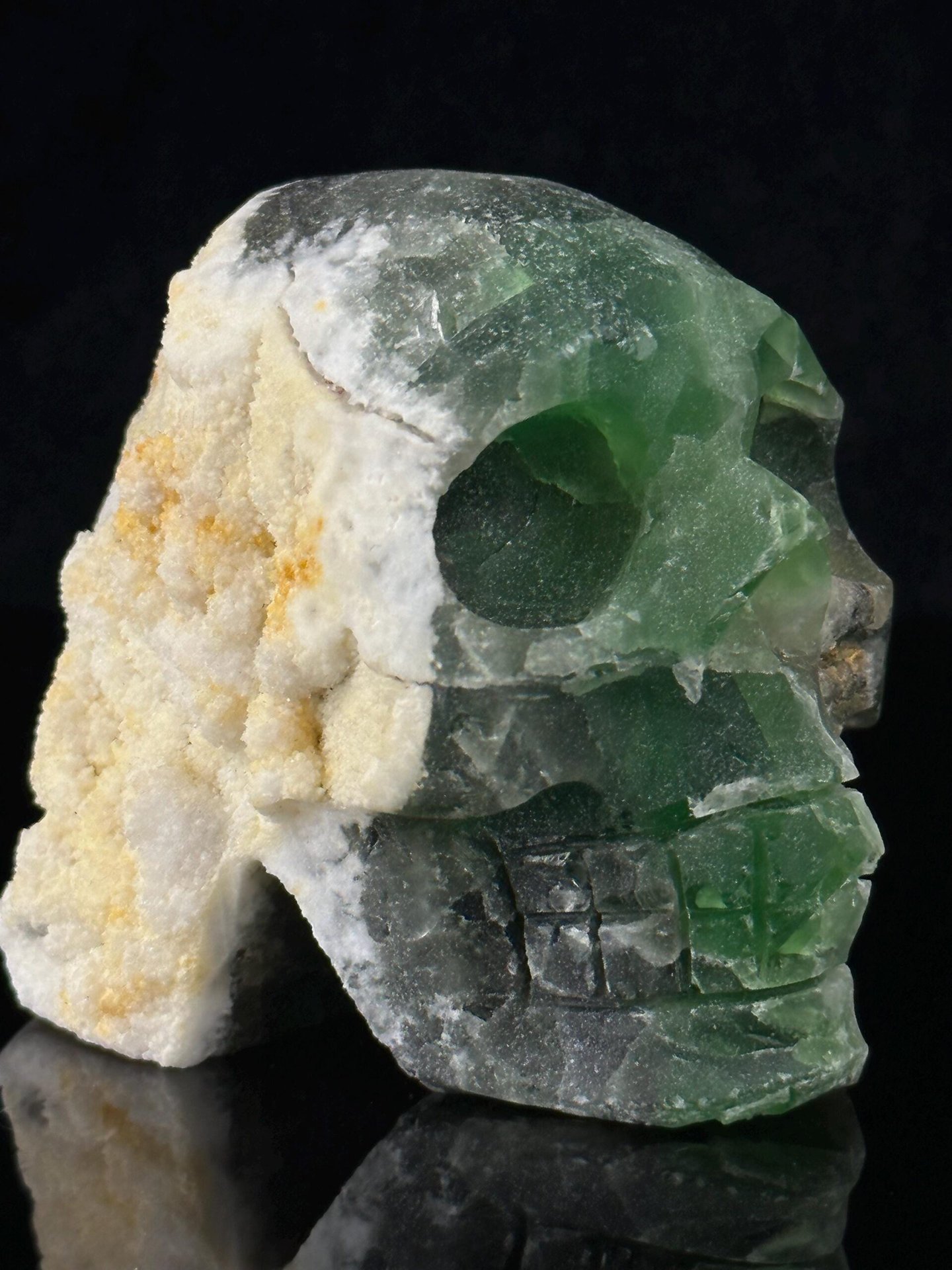 Hand-carved fluorite skull with natural geode cavity interior