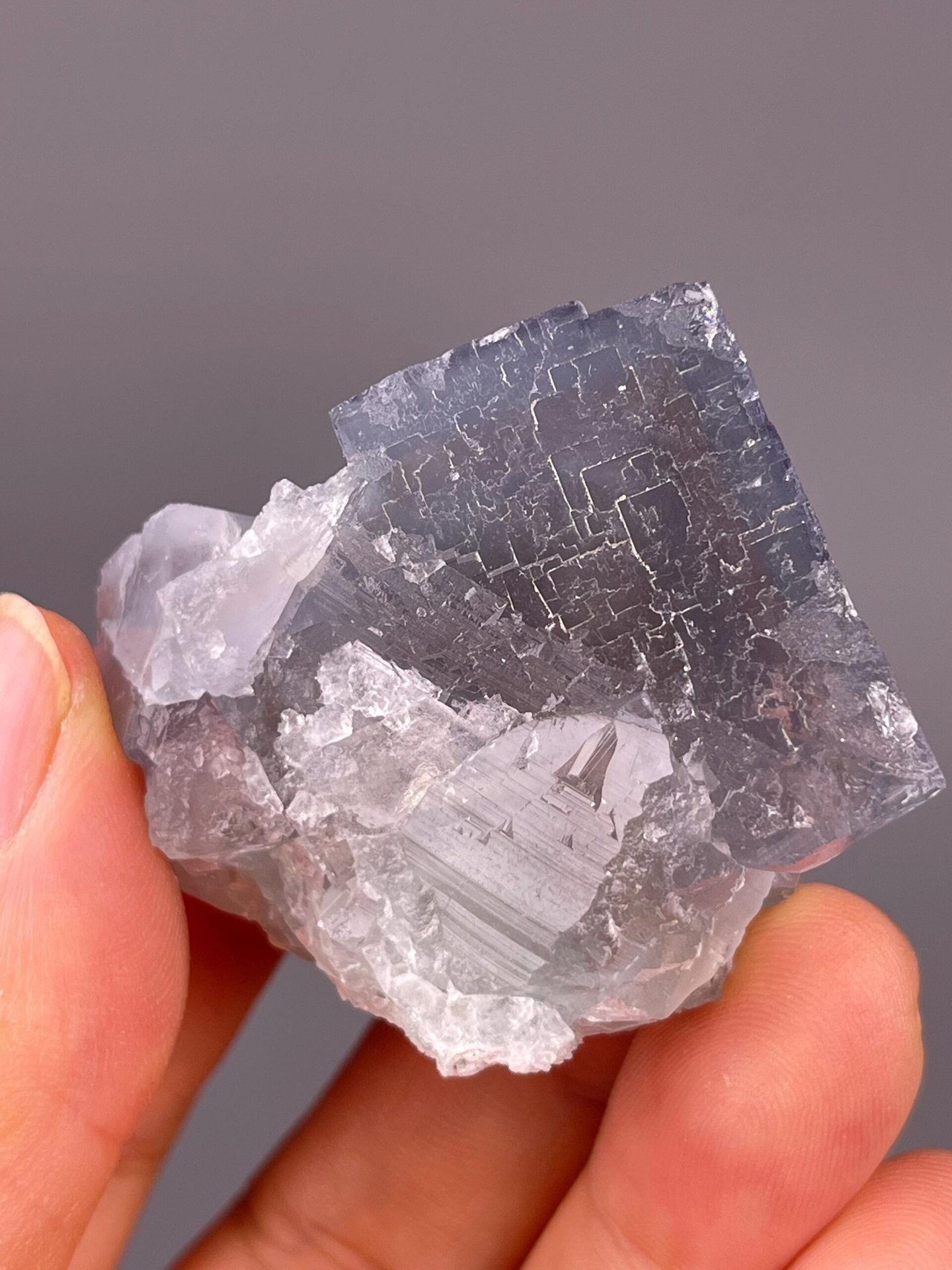Angled view of etched purple-blue fluorite cube